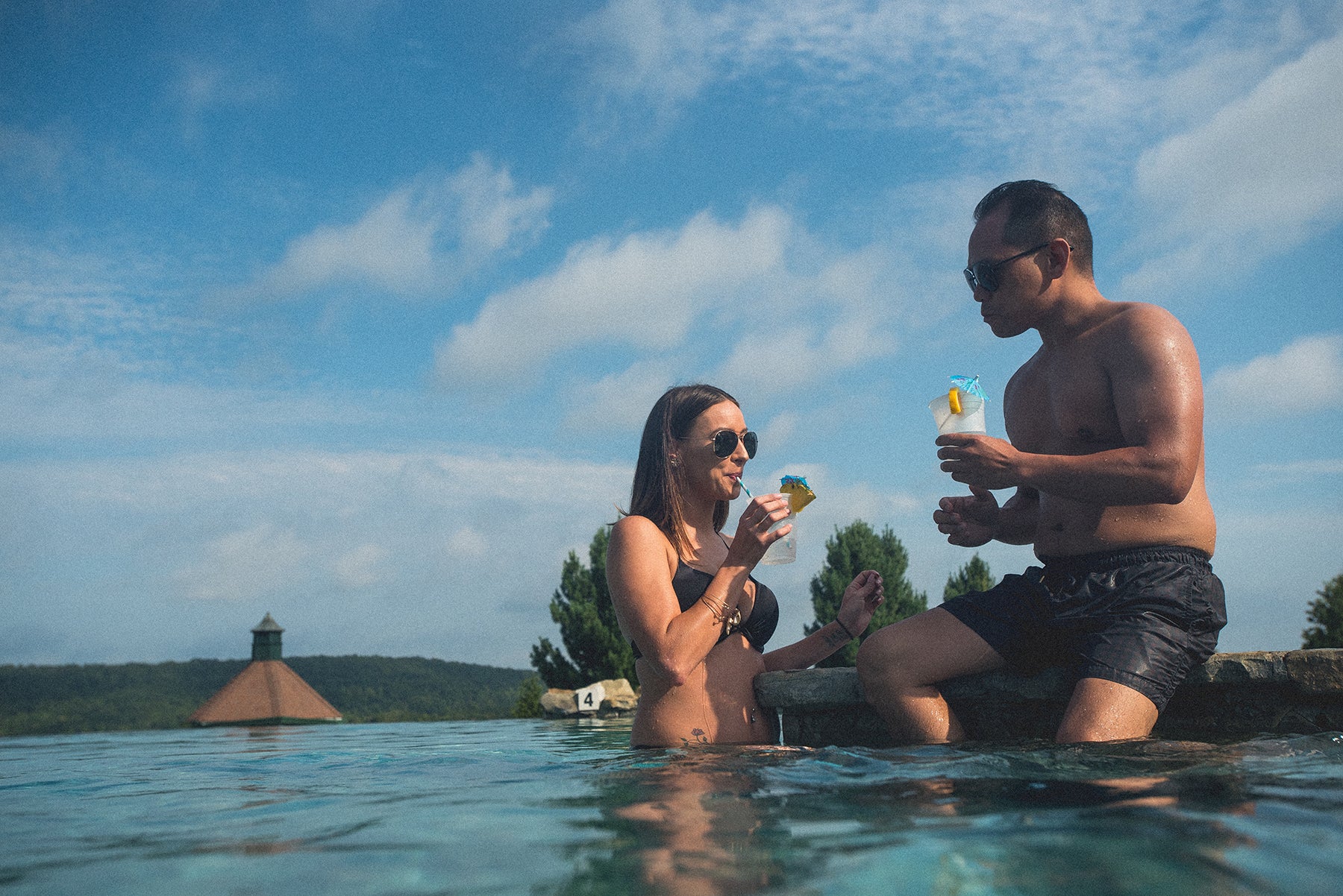 Couple enjoying cocktails at a resort outdoor pool