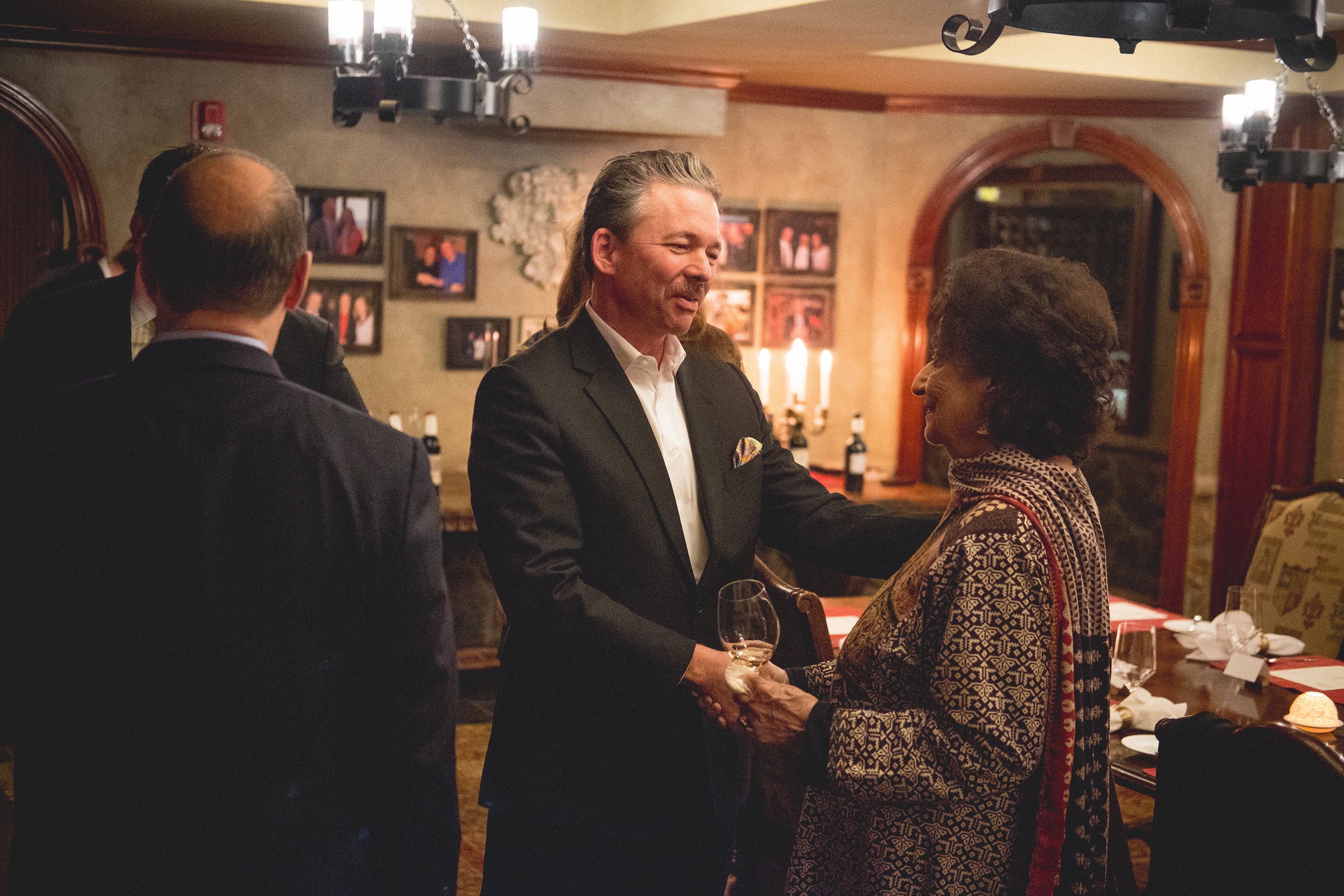 Man and woman shaking hands in the wine cellar.