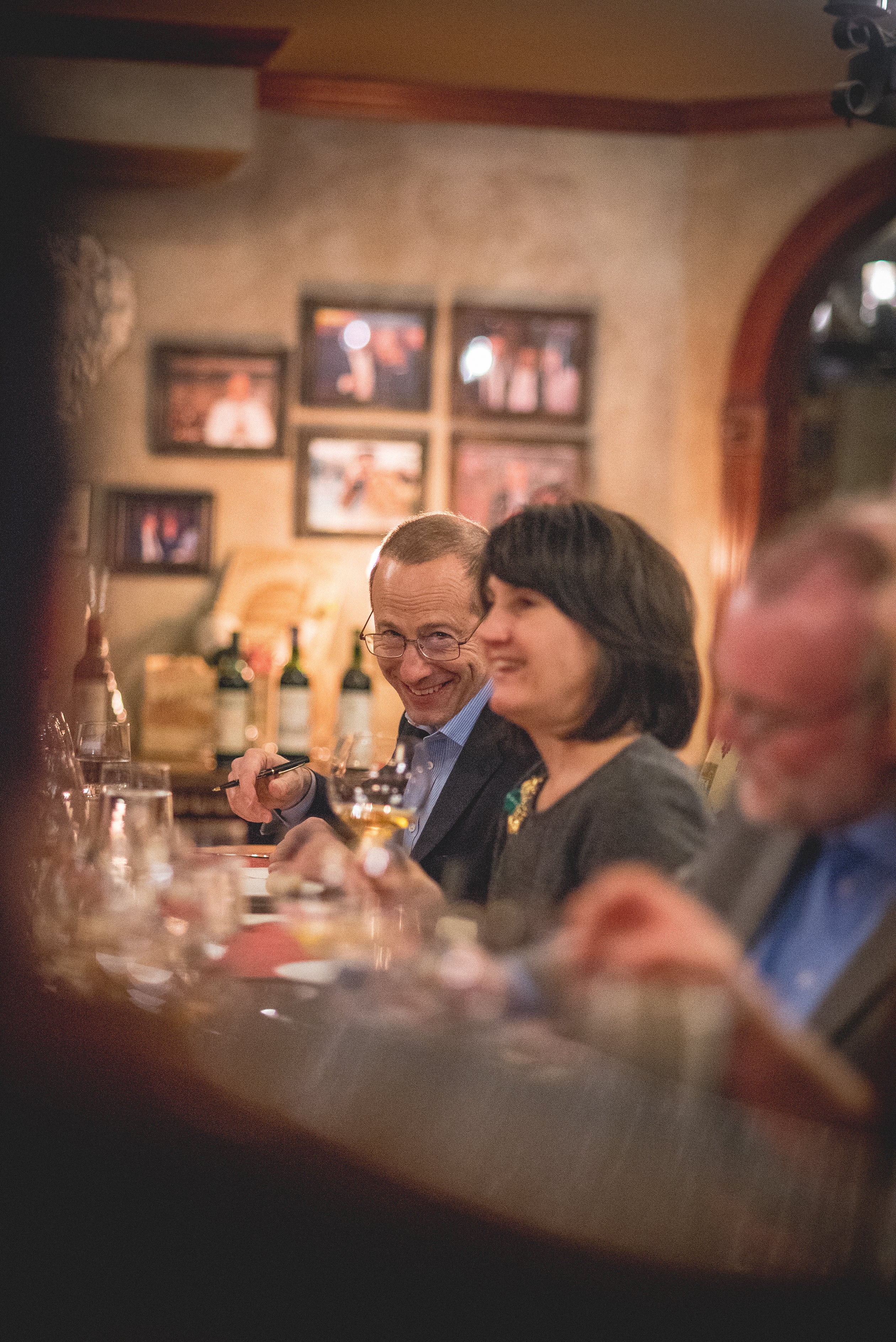 Man and woman laughing during wine cellar dinner.