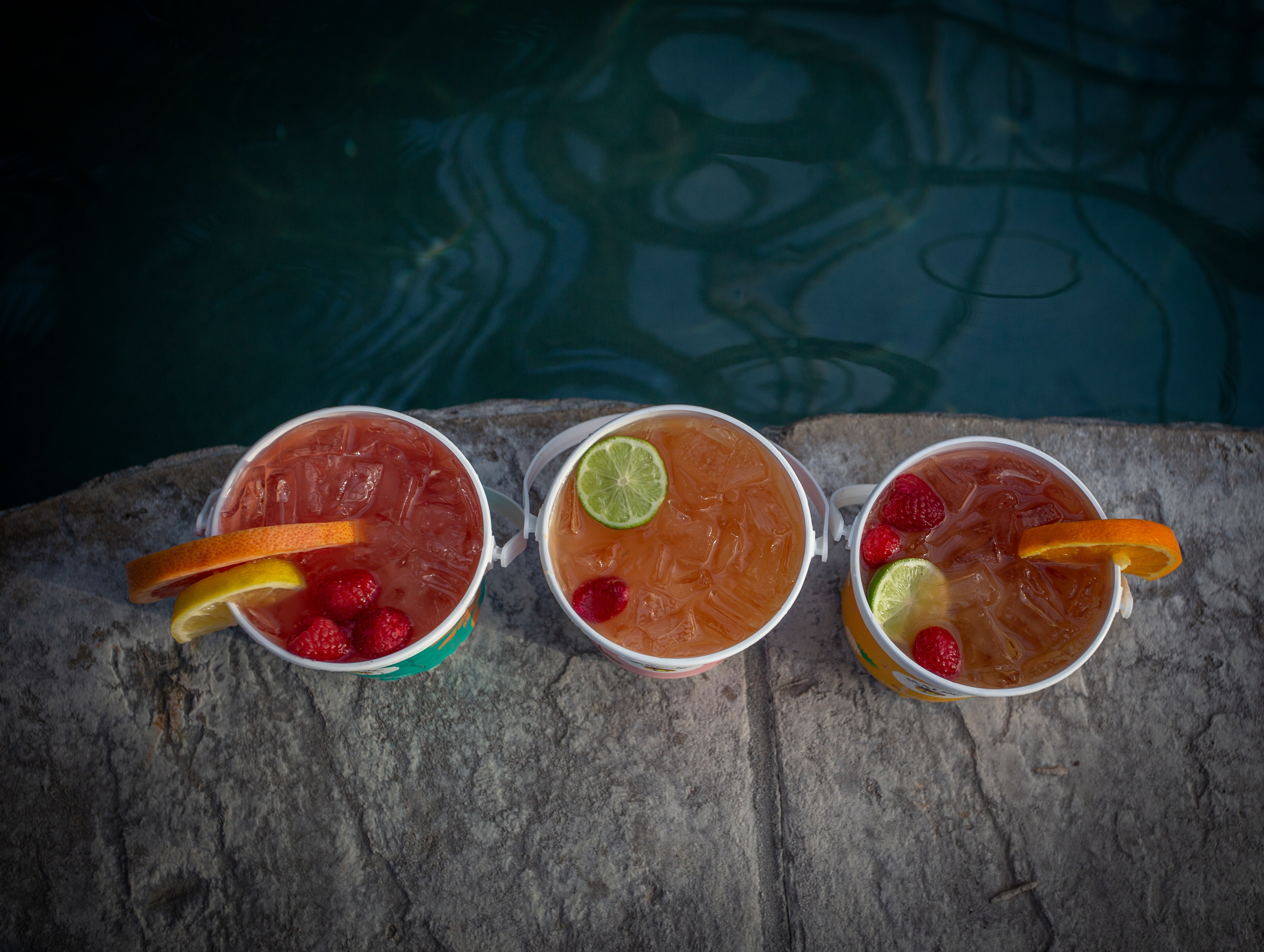 Aerial view of three rum buckets with fresh fruit.
