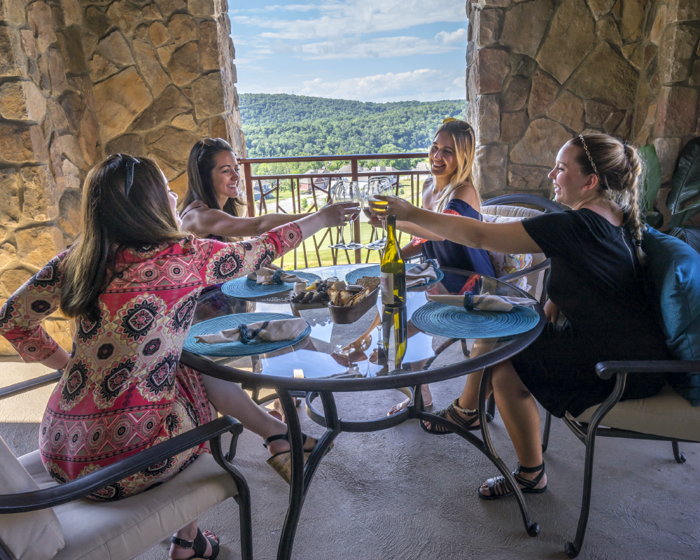 Girlfriends enjoying drinks on hotel balcony at Grand Cascades Lodge