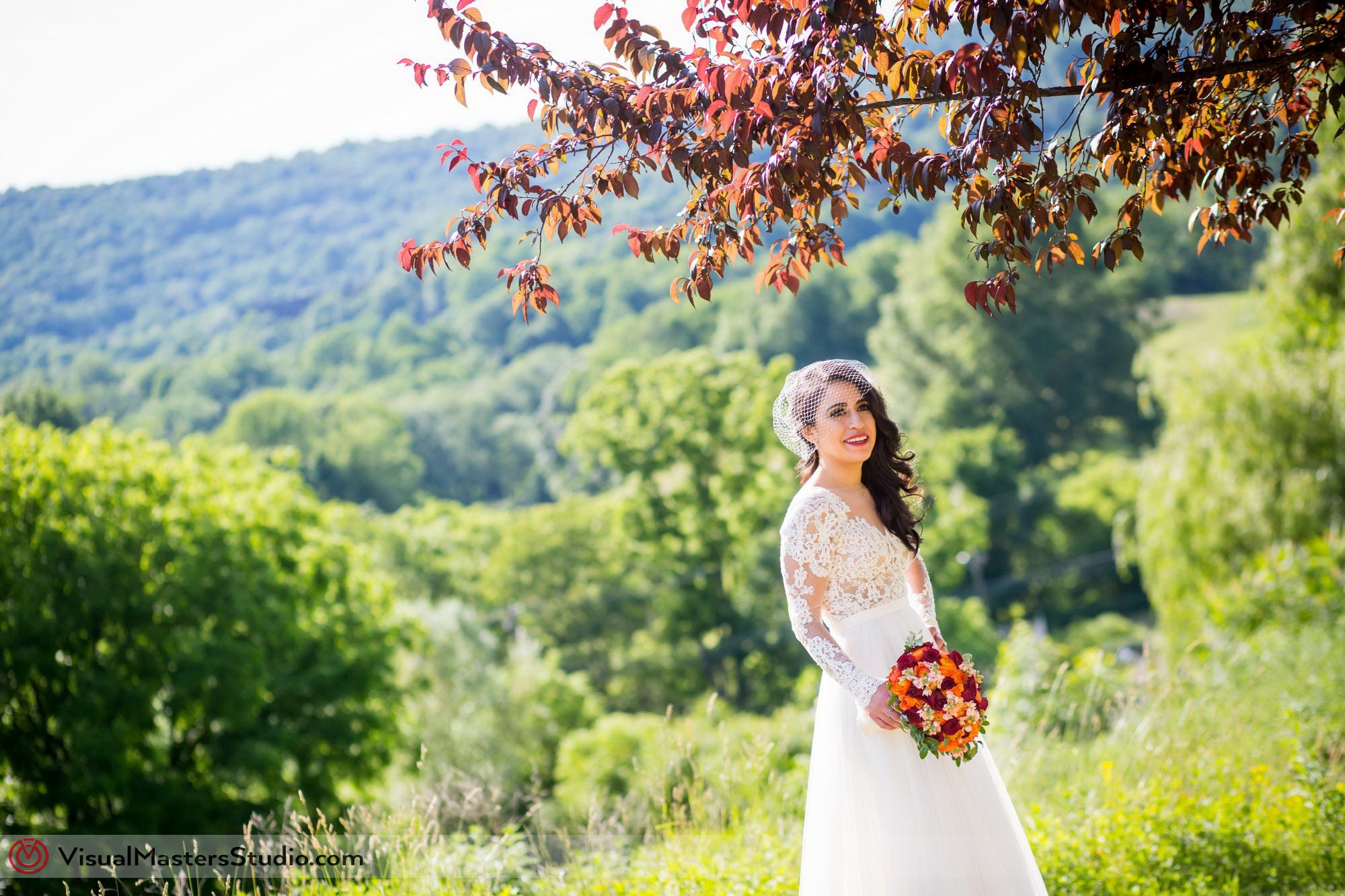 Bride smiling under autumn tree