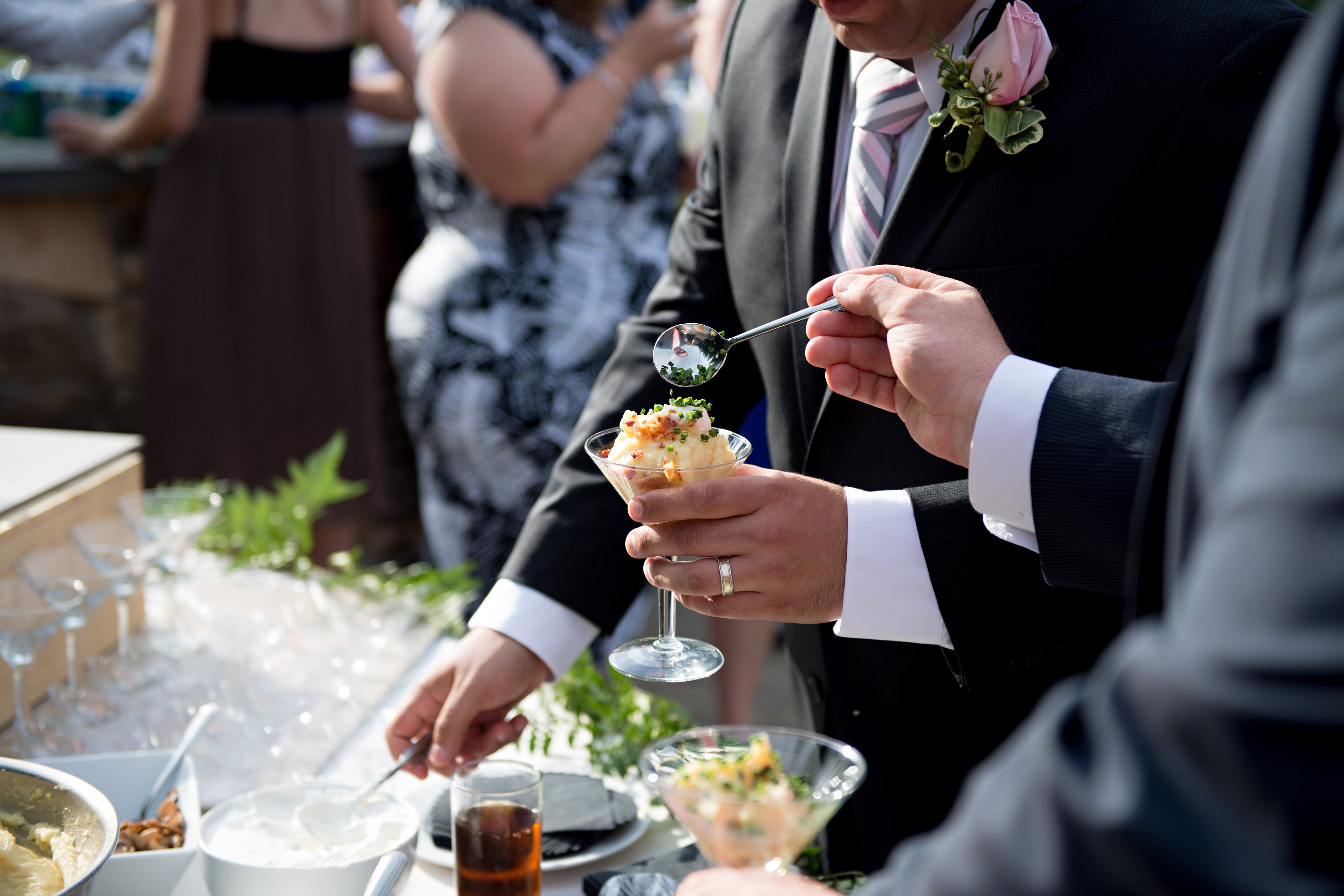 Men serving food at wedding cocktail hour