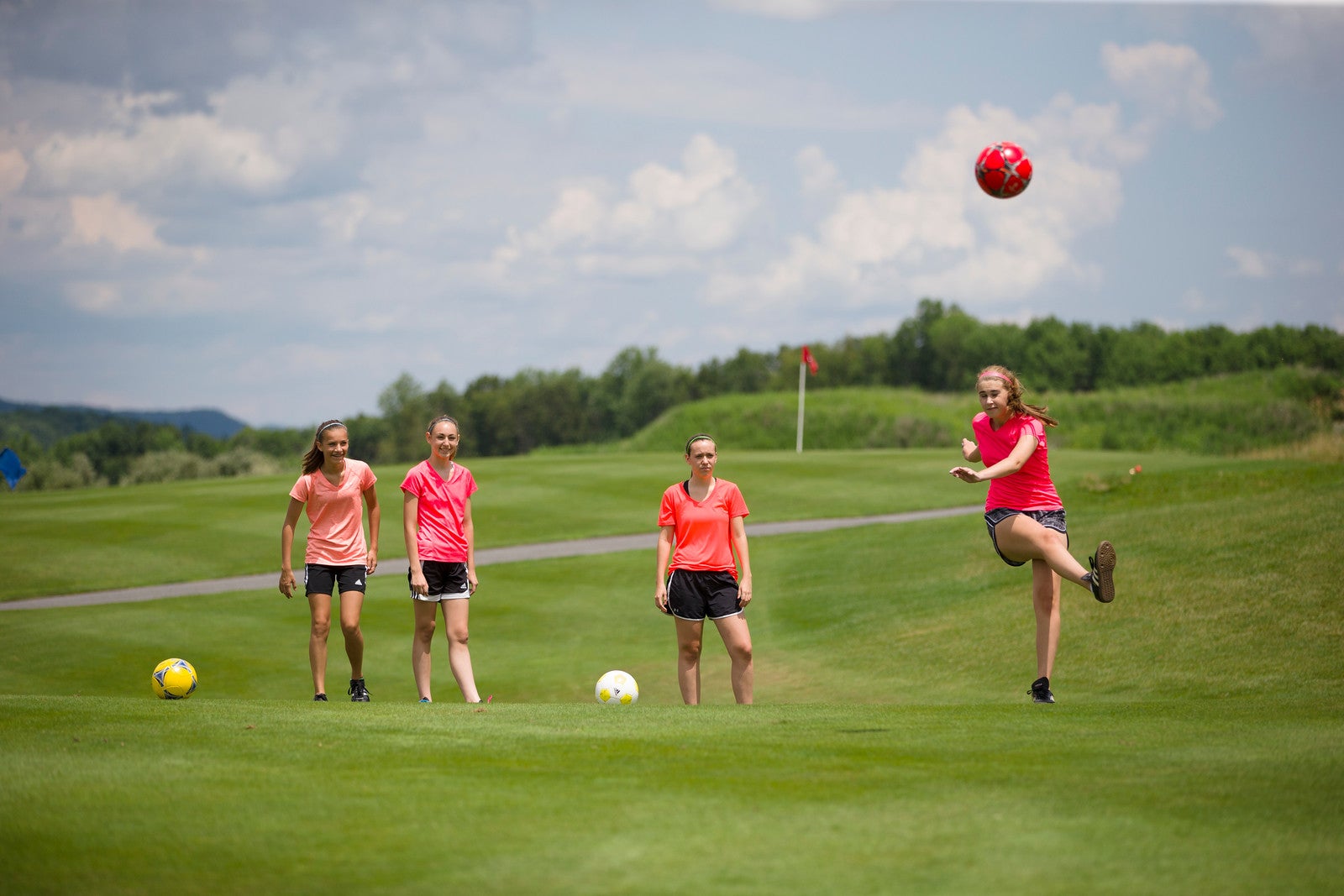 Young girls playing foot golf on a golf course at Crystal Springs Resort