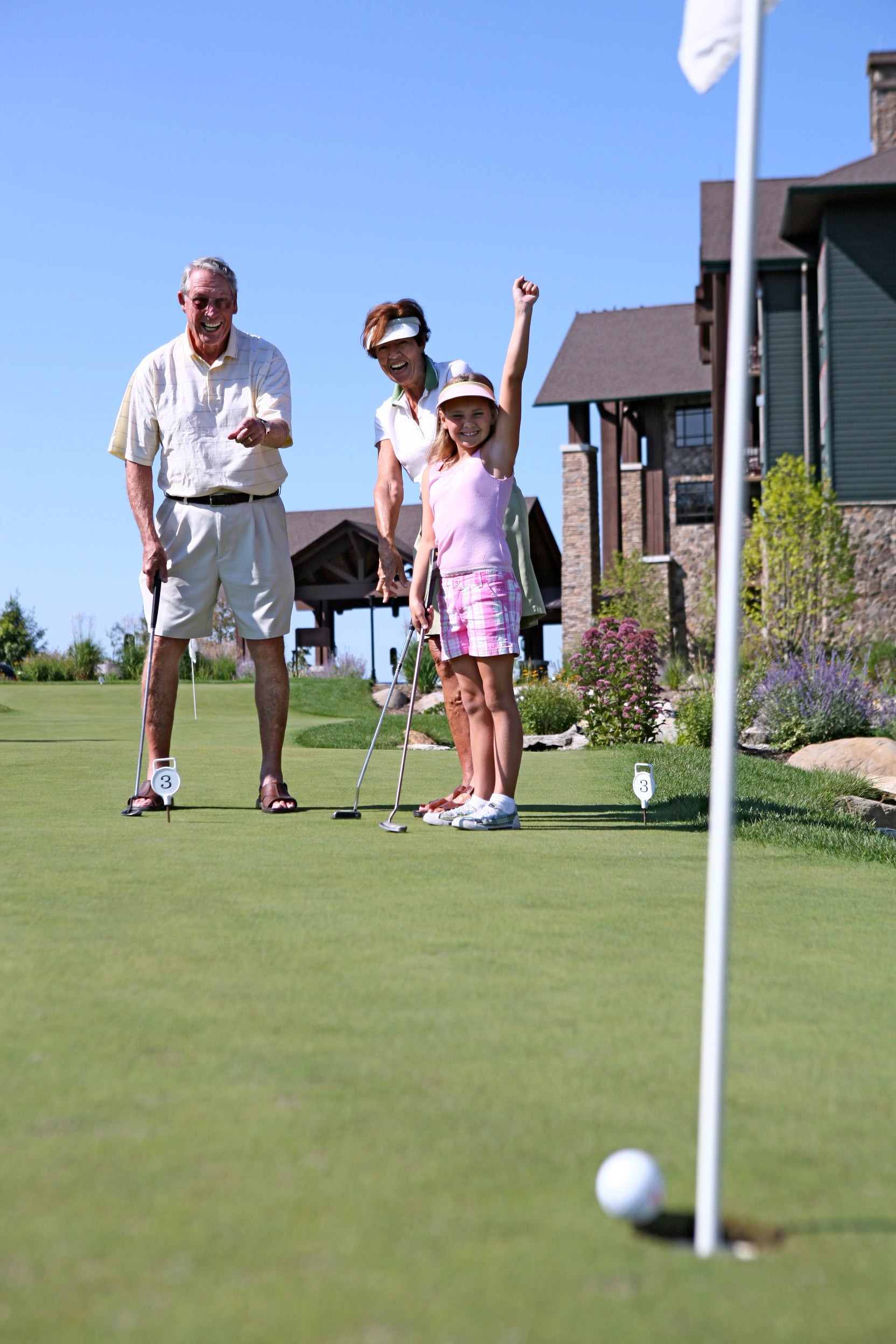 A family playing golf on the putting green at Crystal Springs Resort