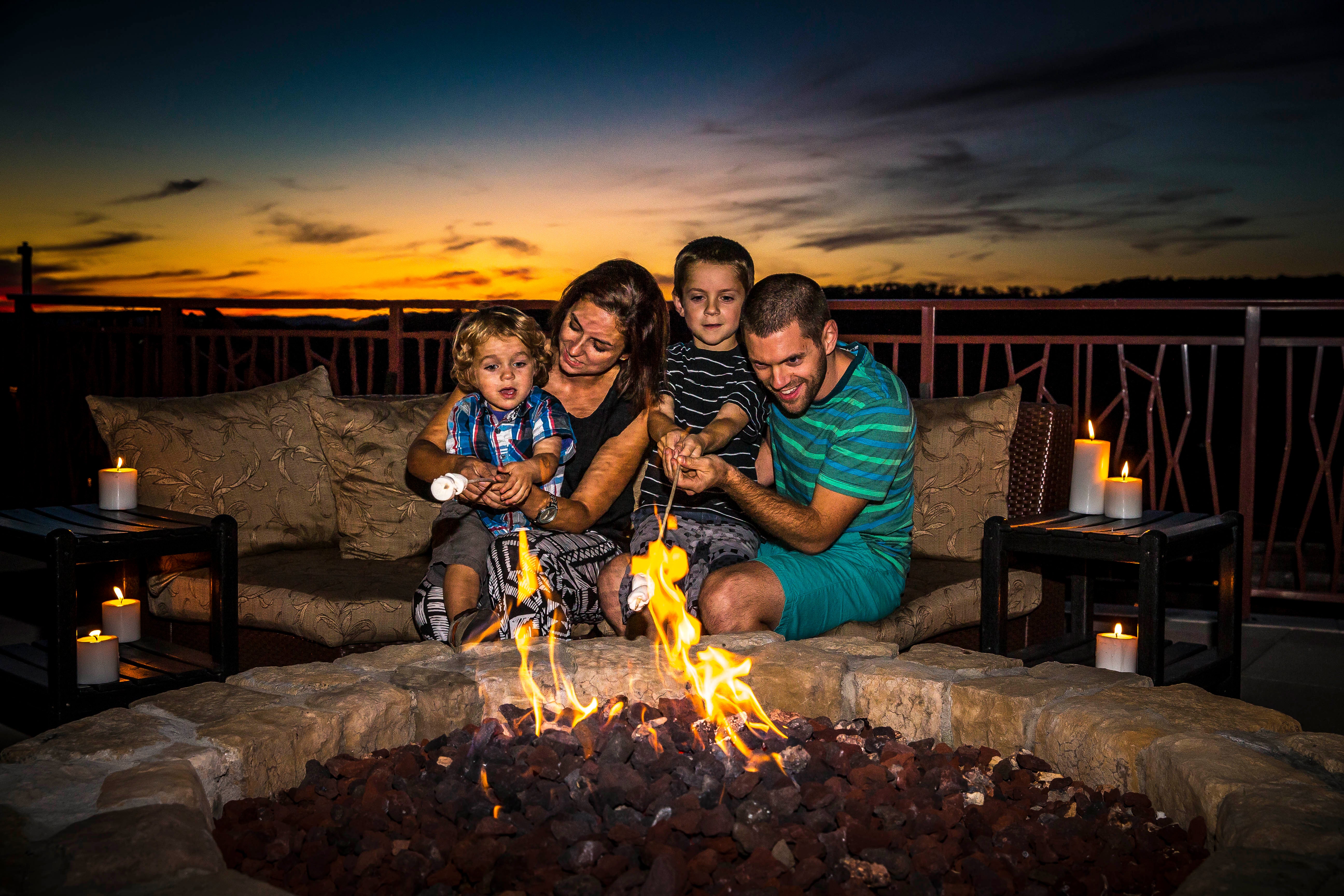Family roasting marshmallows on the Fire and Water Terrace at Grand Cascades Lodge.