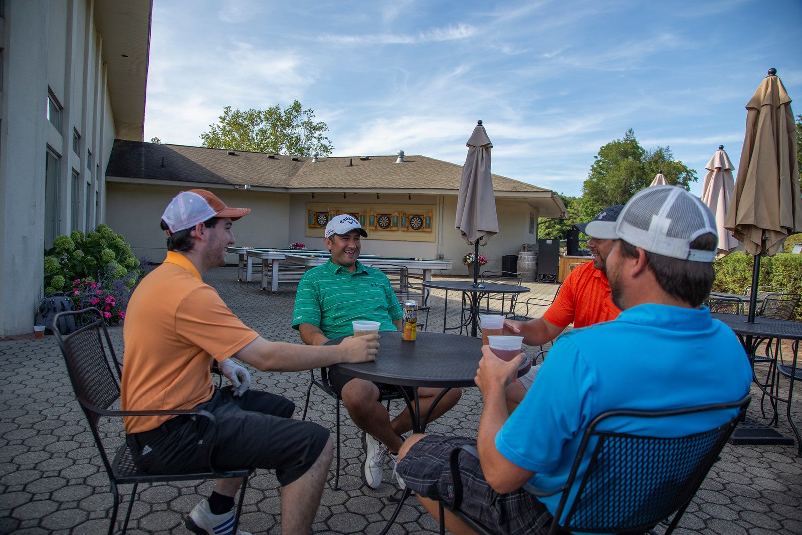 Four guys sitting outside on the patio at the Bear Den Grill