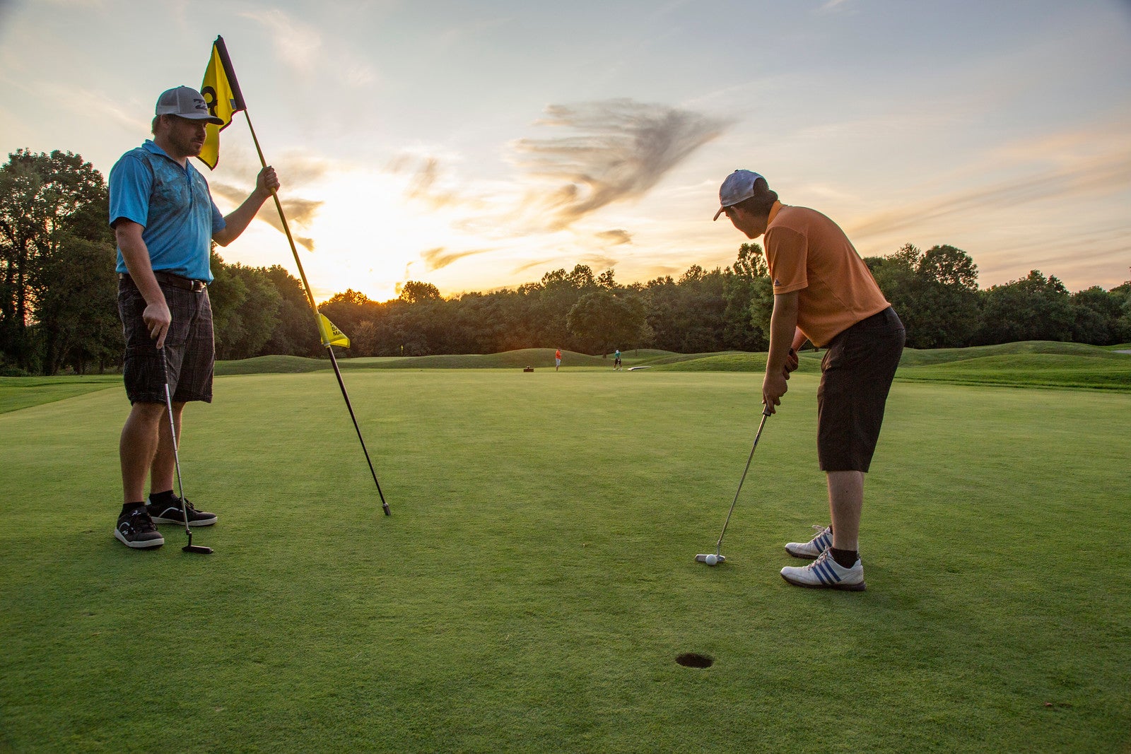 Two men on the putting green of a hole at Black Bear Golf course