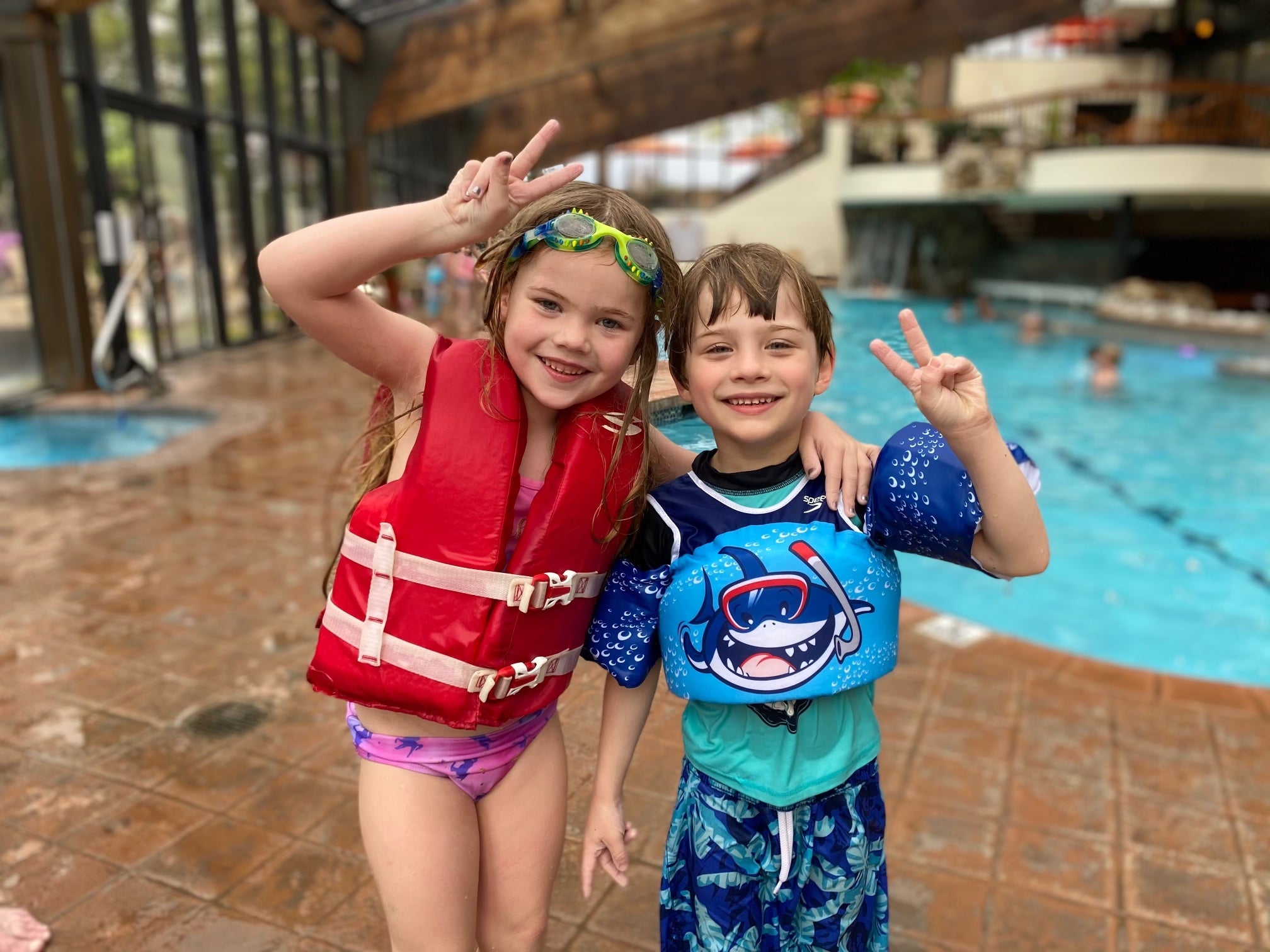 Young children holding up peace signs at Minerals indoor pools