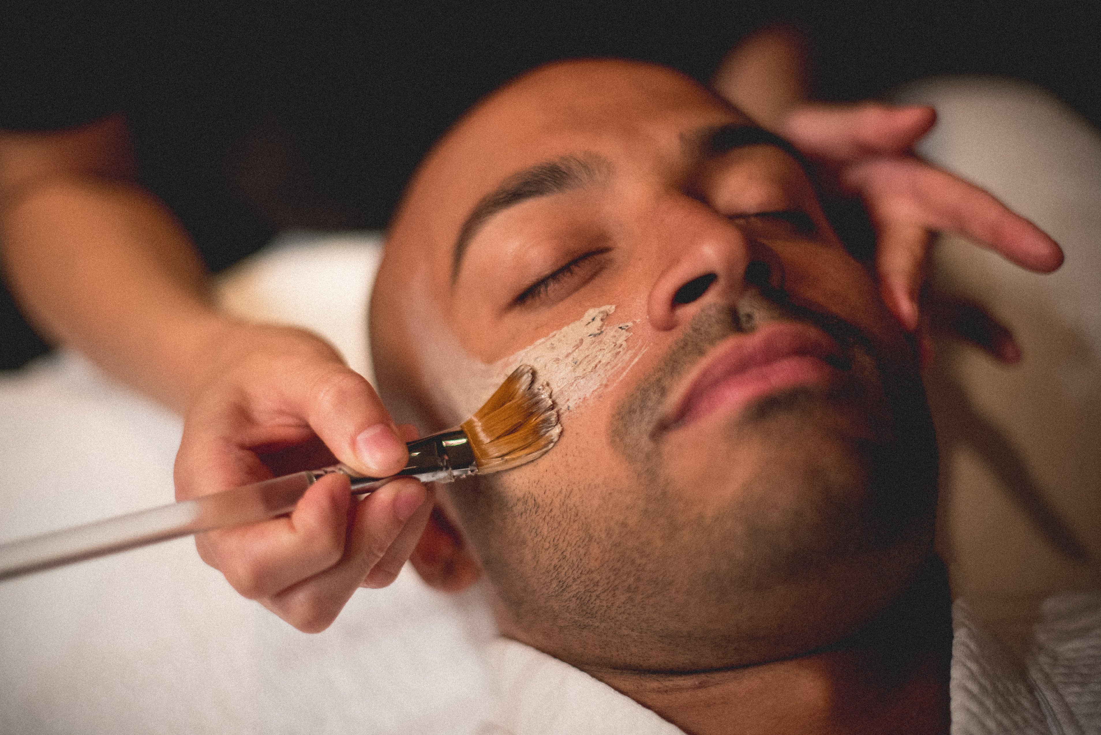 Mask being applied to man's face during facial