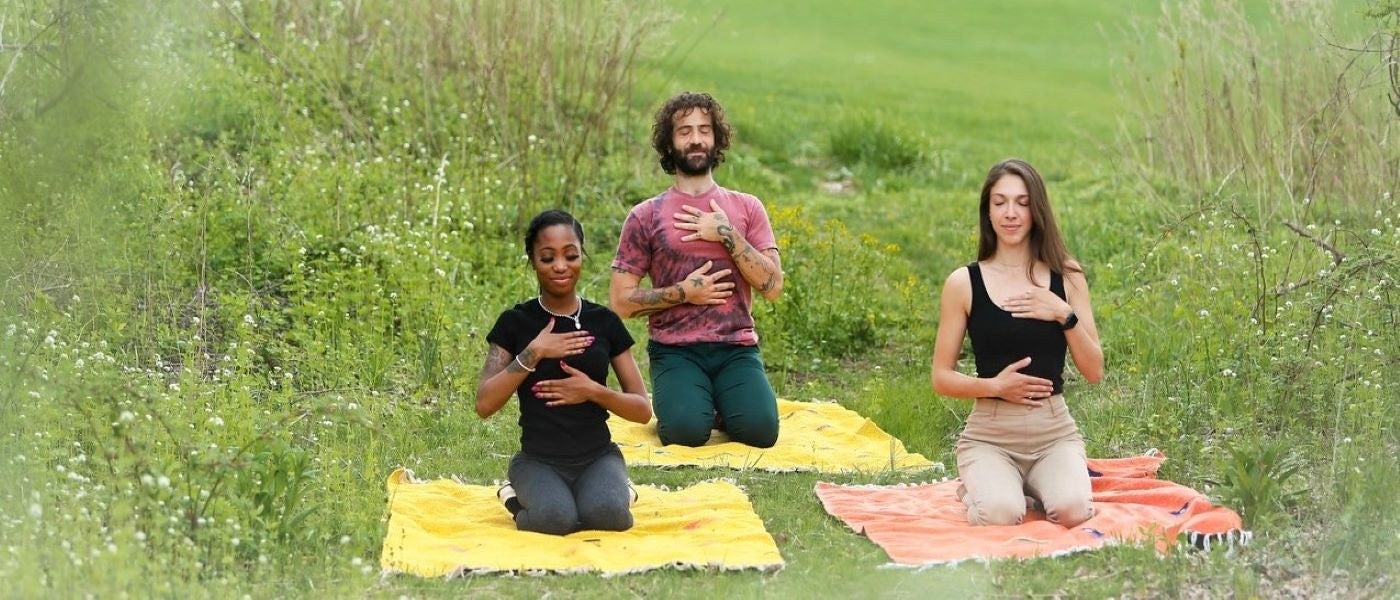 Group of three people meditating in a field  in New Jersey. 