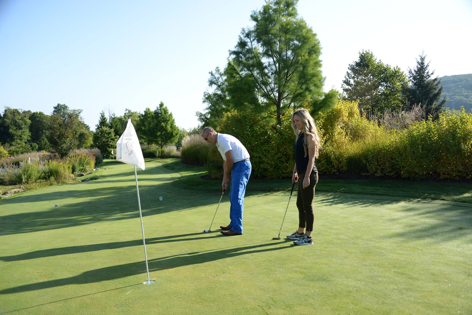 A couple playing mini golf on the natural putting green at Grand Cascades Lodge