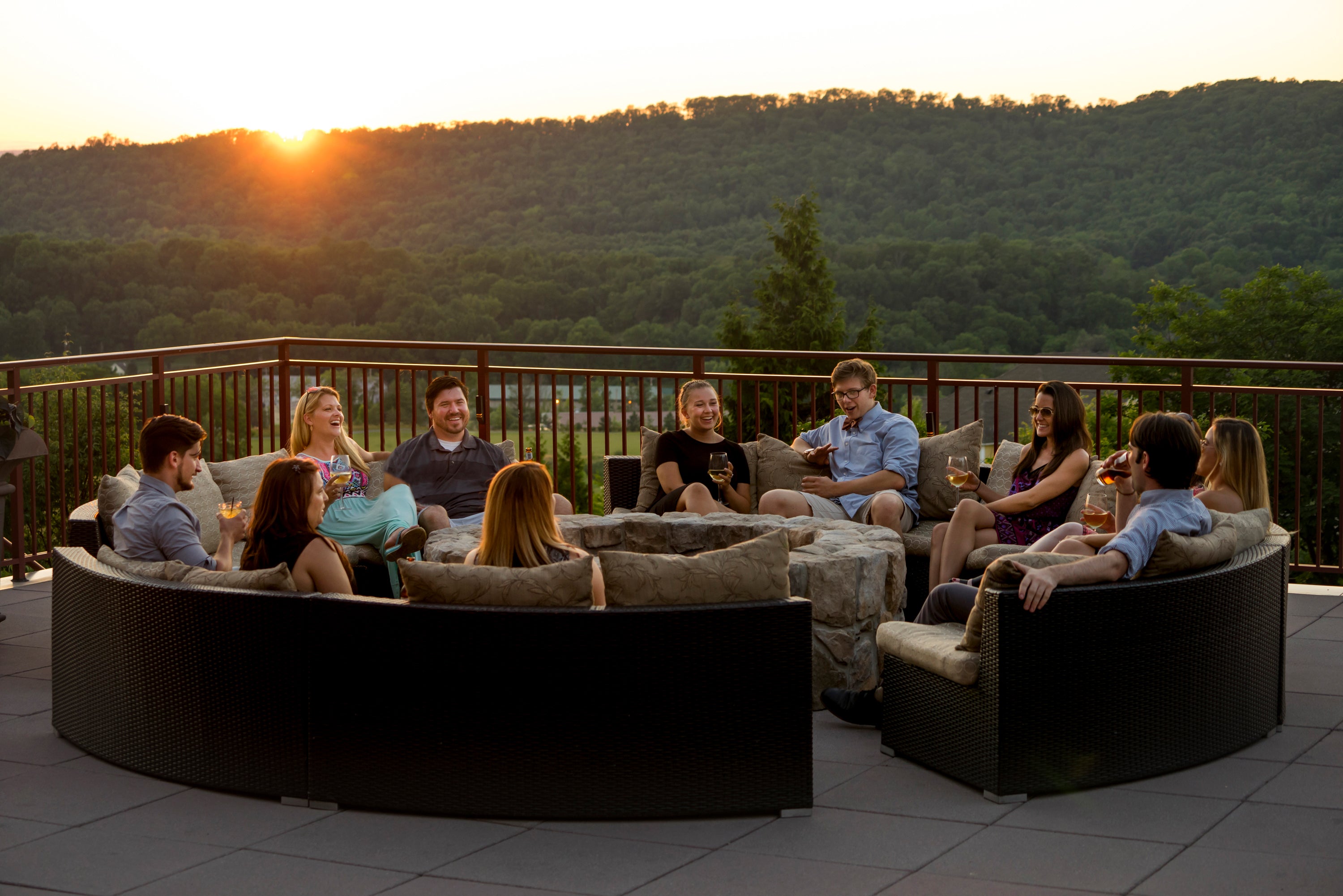 A corporate group enjoying drinks on the Fire + Water Terrace at sunset