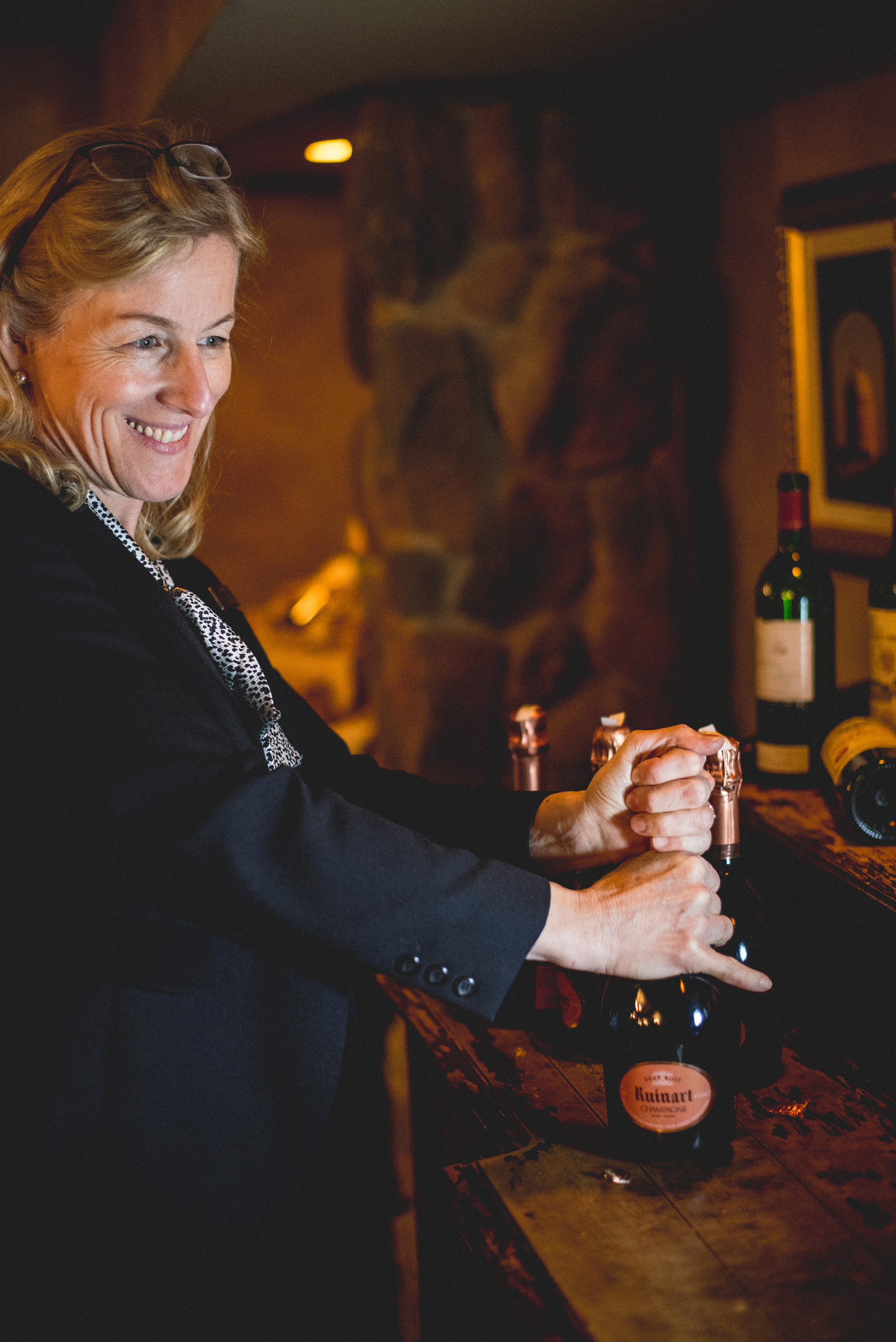 Susanne Wagner opening a bottle of wine.