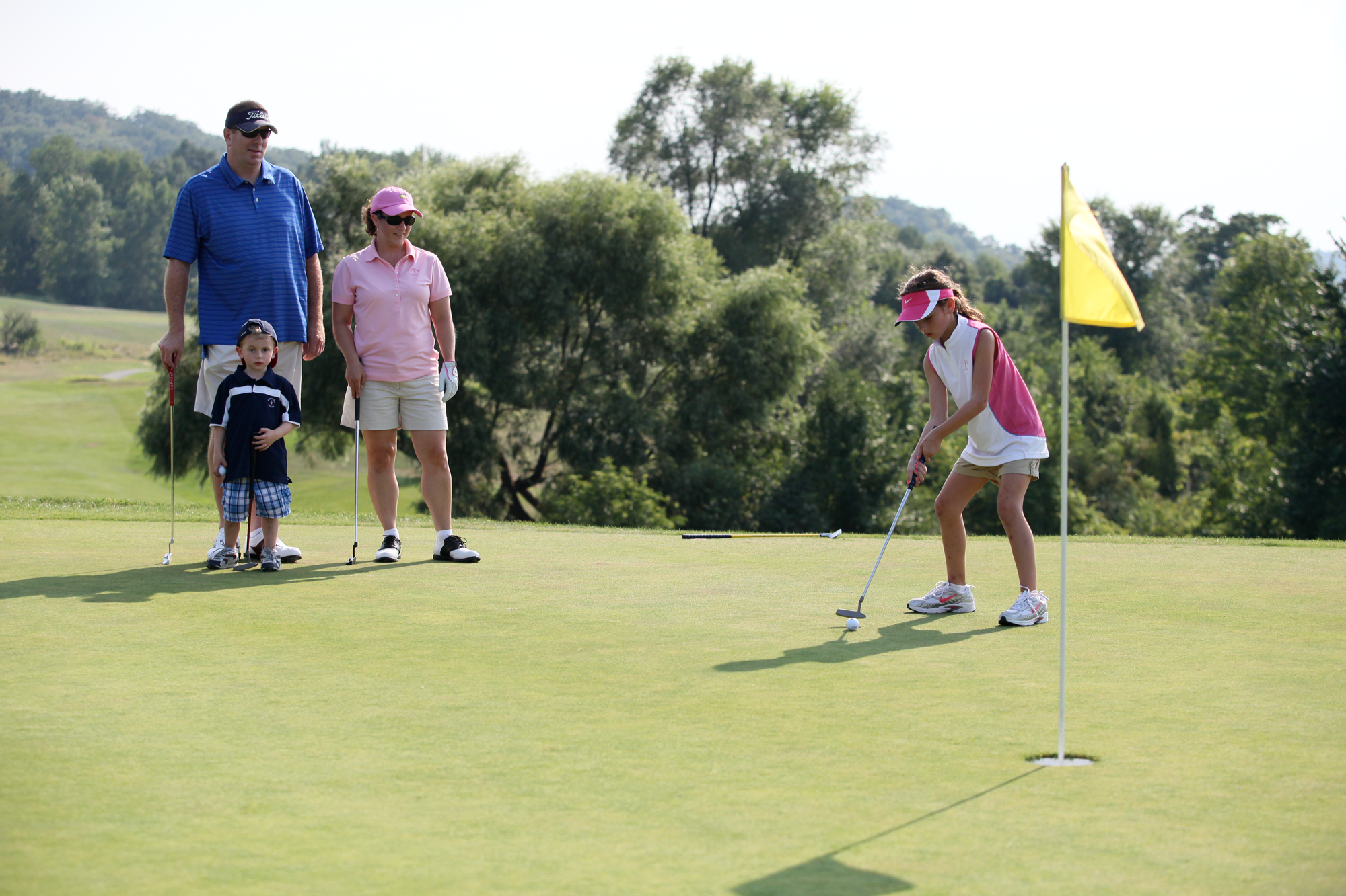 Young girl and family on the putting green on a course at Crystal Springs Resort