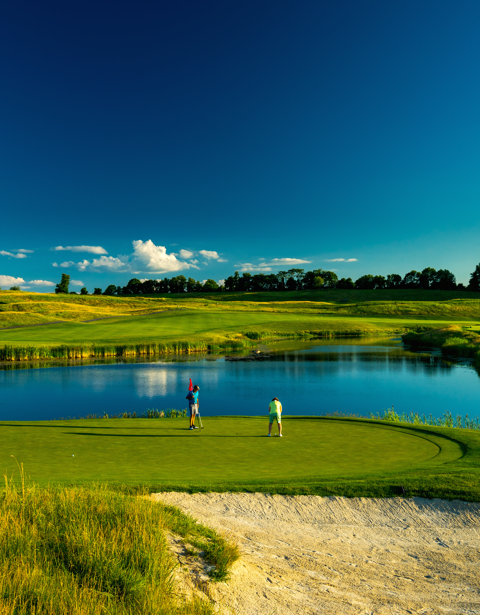 Two guys on the putting green of a golf course at Crystal Springs Resort