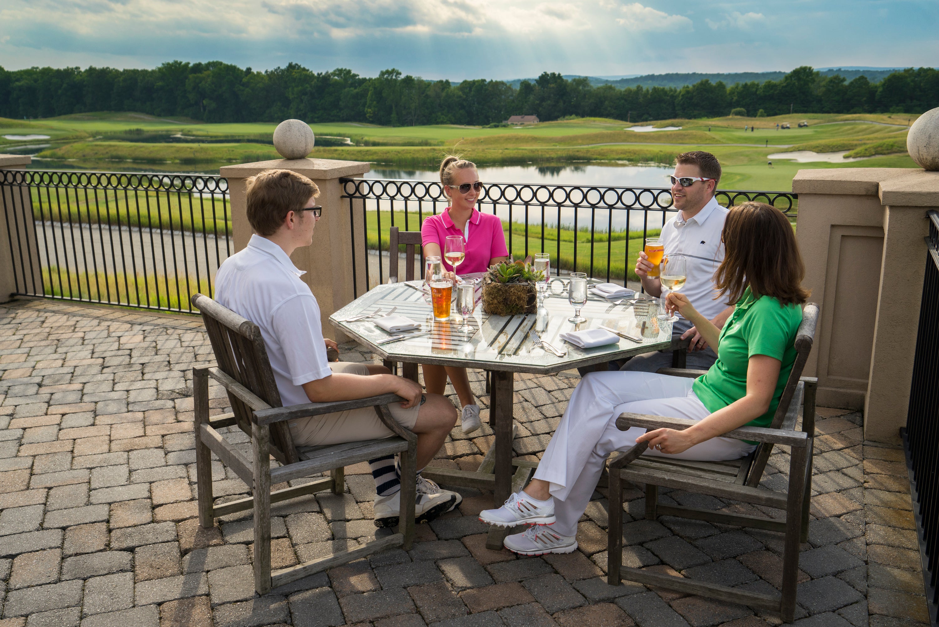 Two couples enjoying outdoor dining on the patio at Ballyowen Golf Club