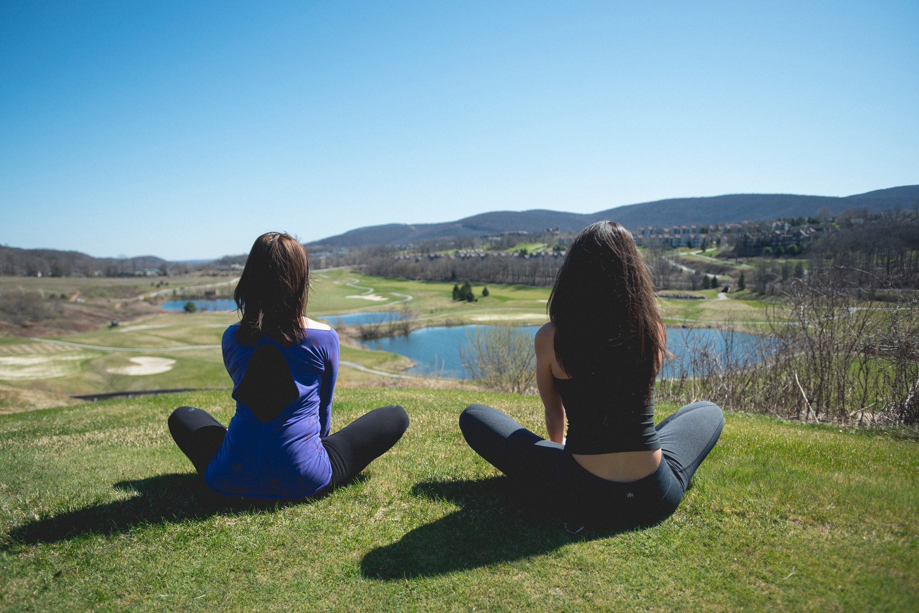 Two women practicing yoga at an overlook