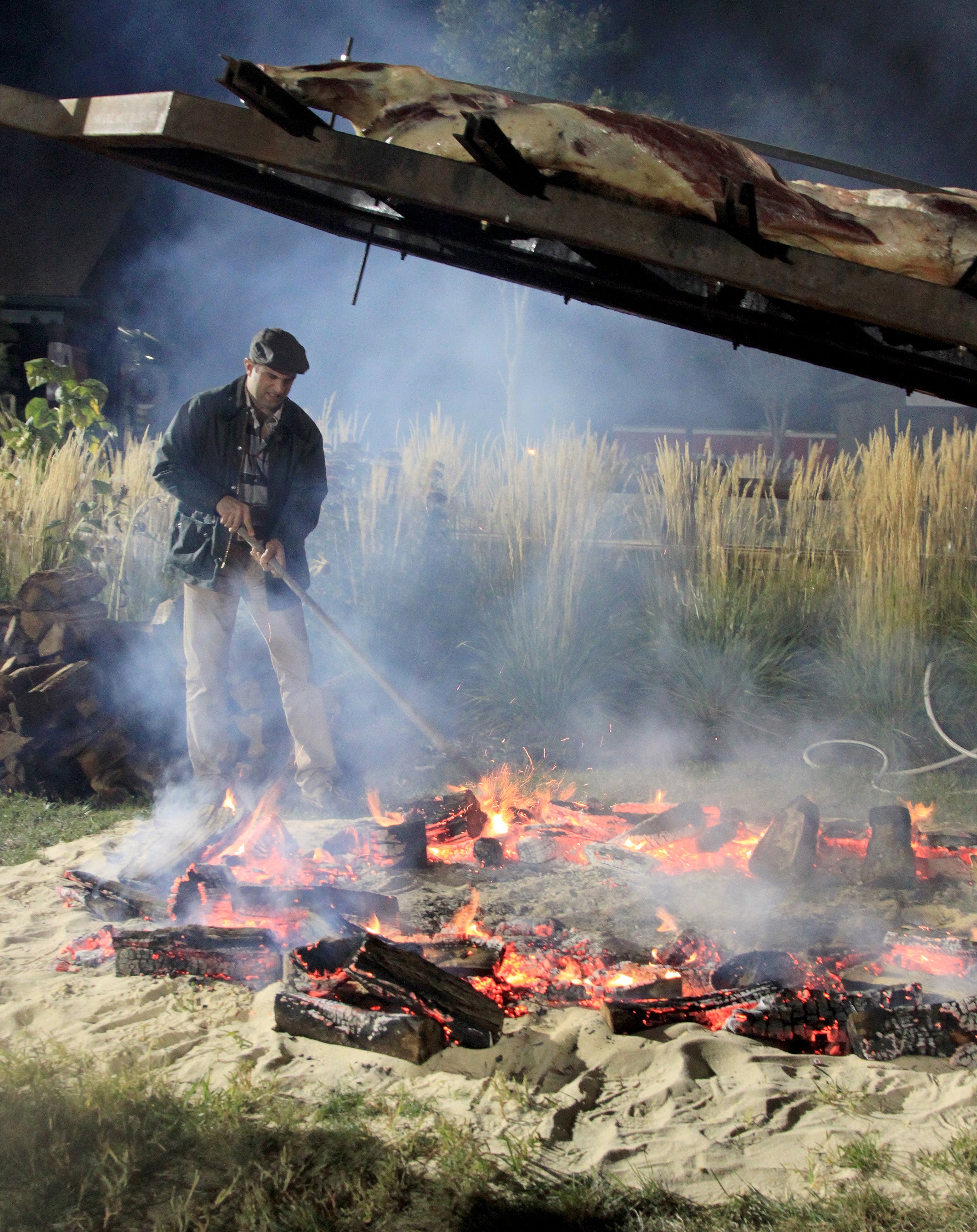 Robby Younes cooking on an open-fire at Mallman Event