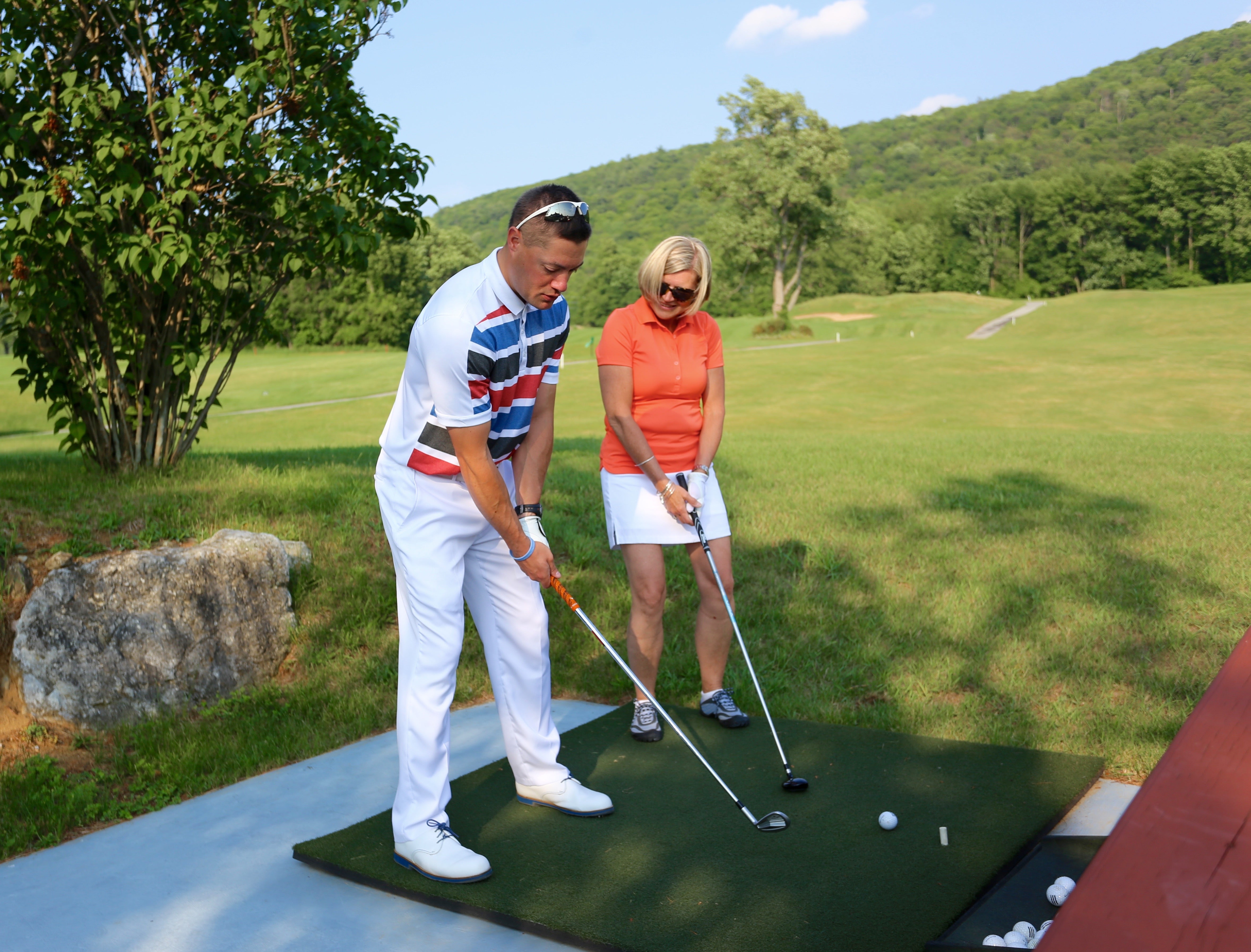 Woman taking golf lessons on the driving range