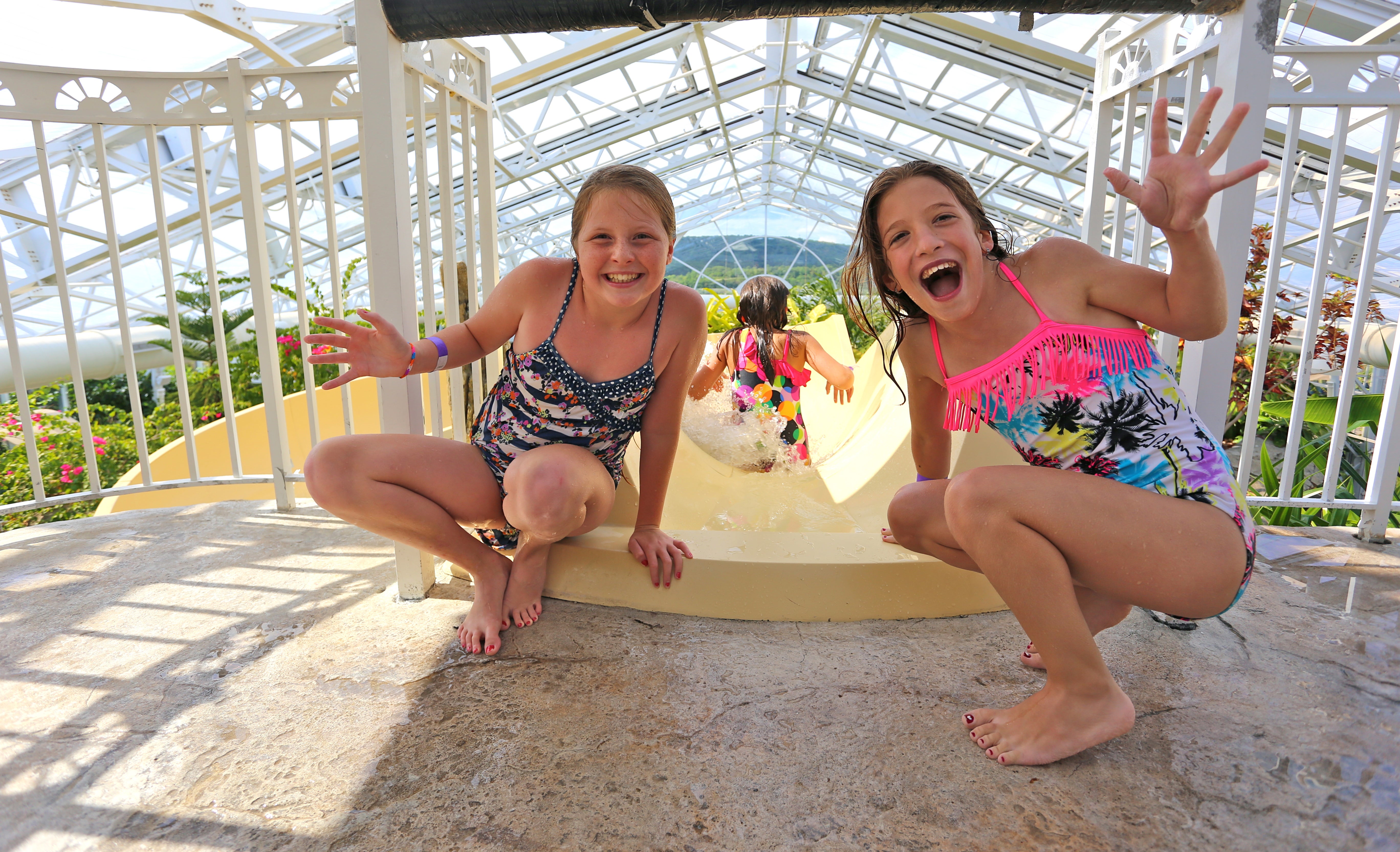 Two girls at top of Biosphere pool complex indoor slide.