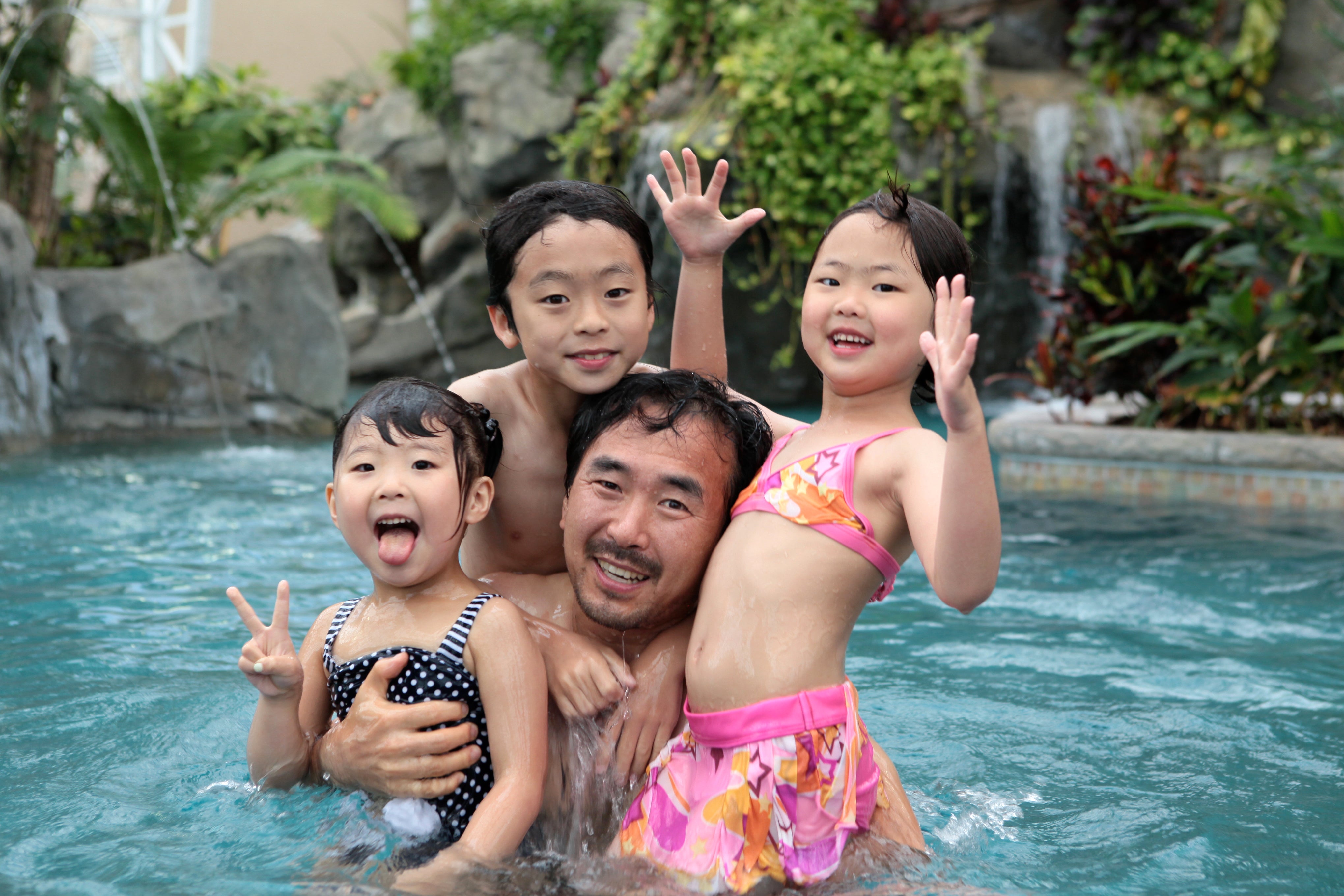 Three children and father in biosphere pool complex.