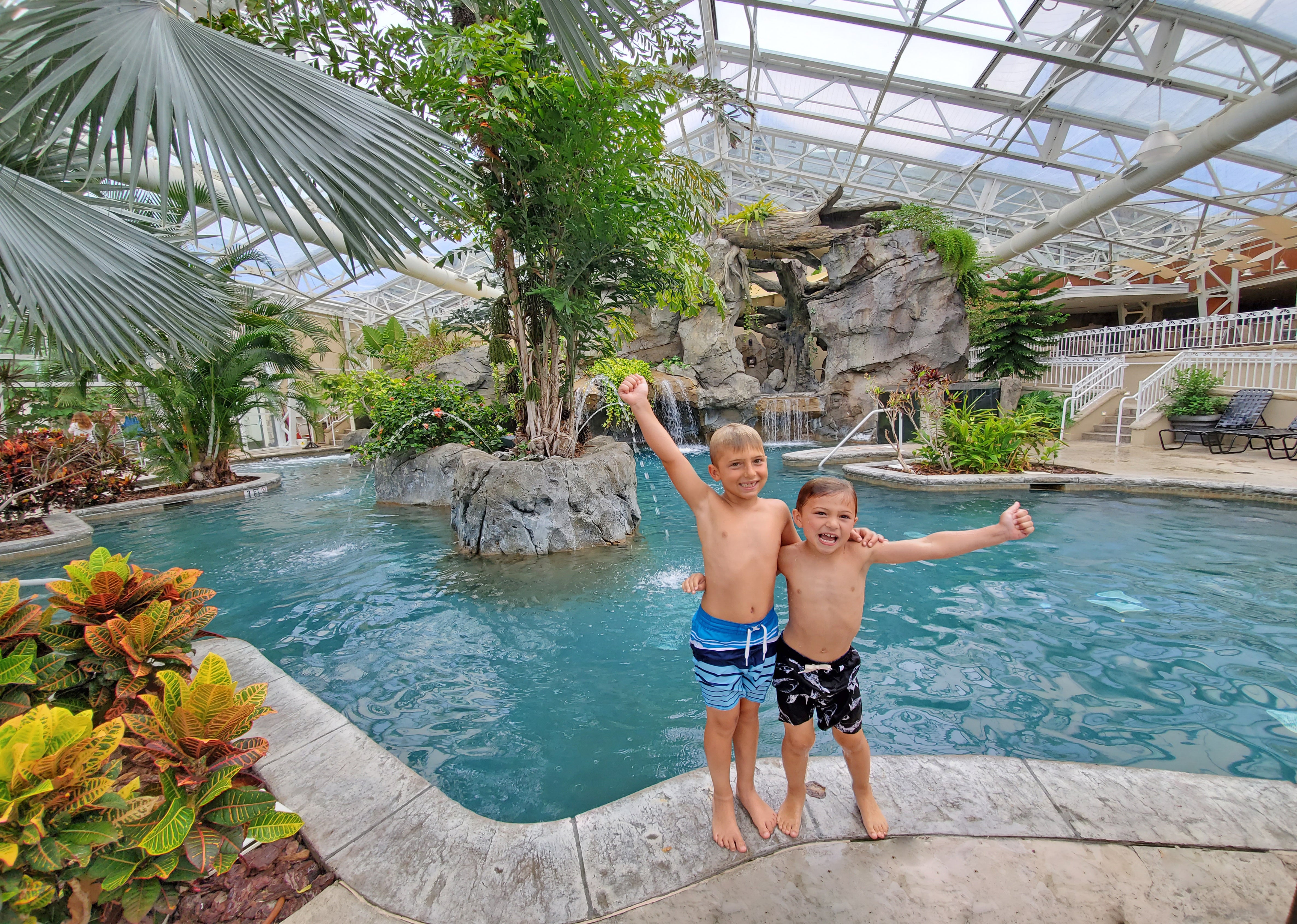 Two boys with their arms around eachother standing outside Biosphere pool.