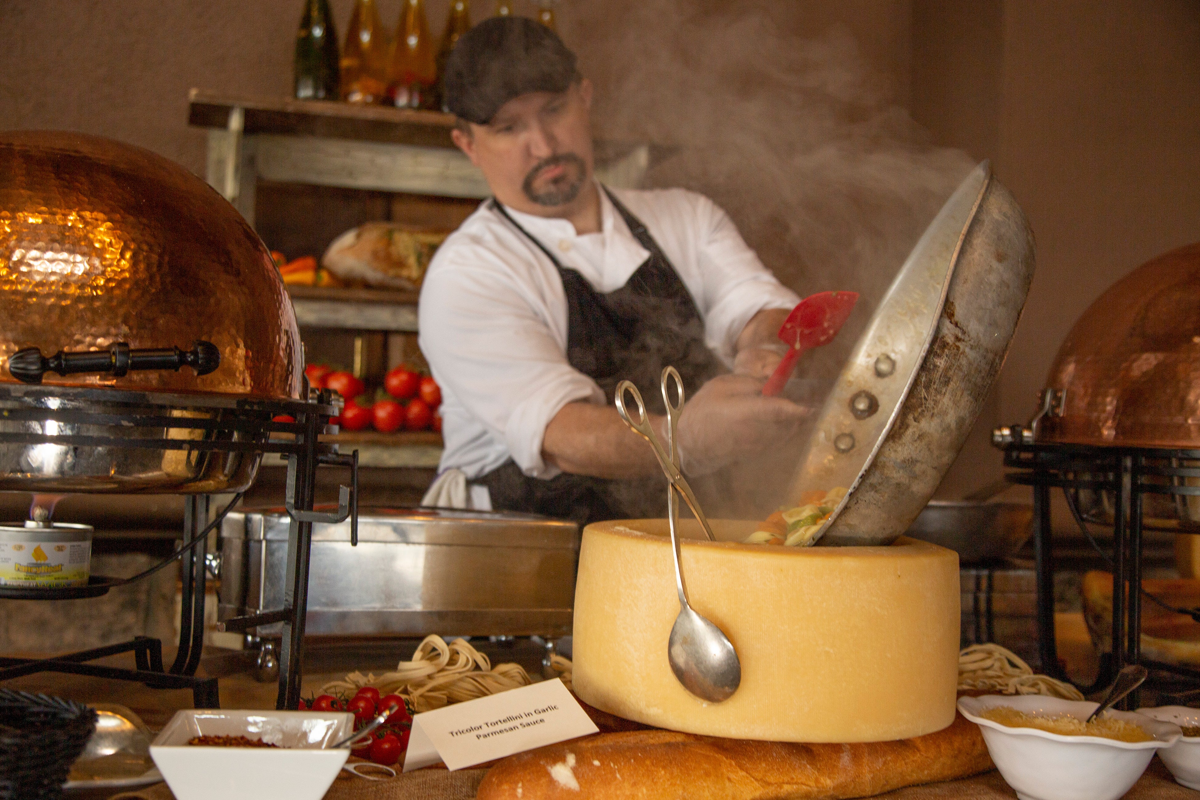Chef making pasta in a cheese wheel