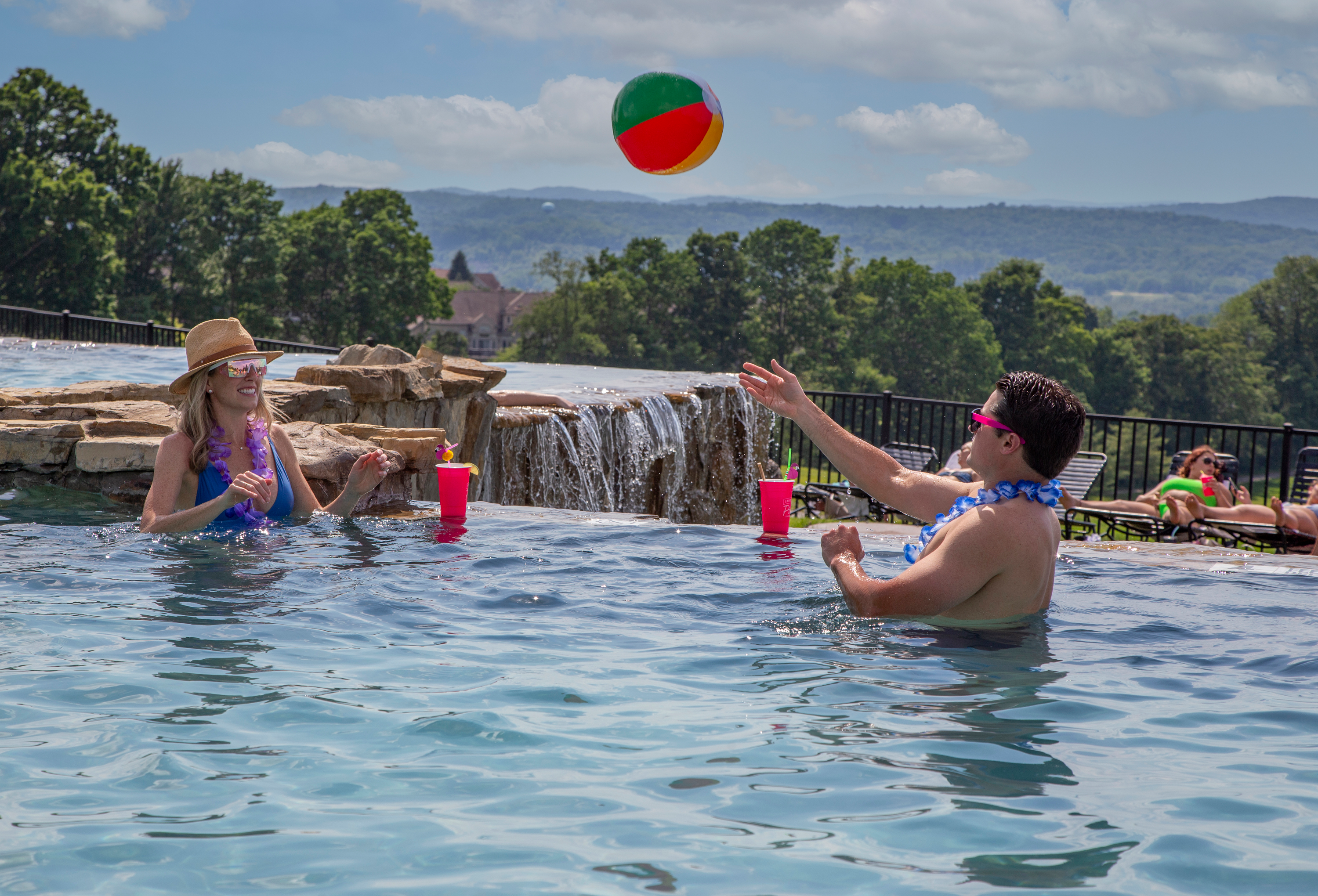 Woman and man playing with beach ball in vista 180 pool.