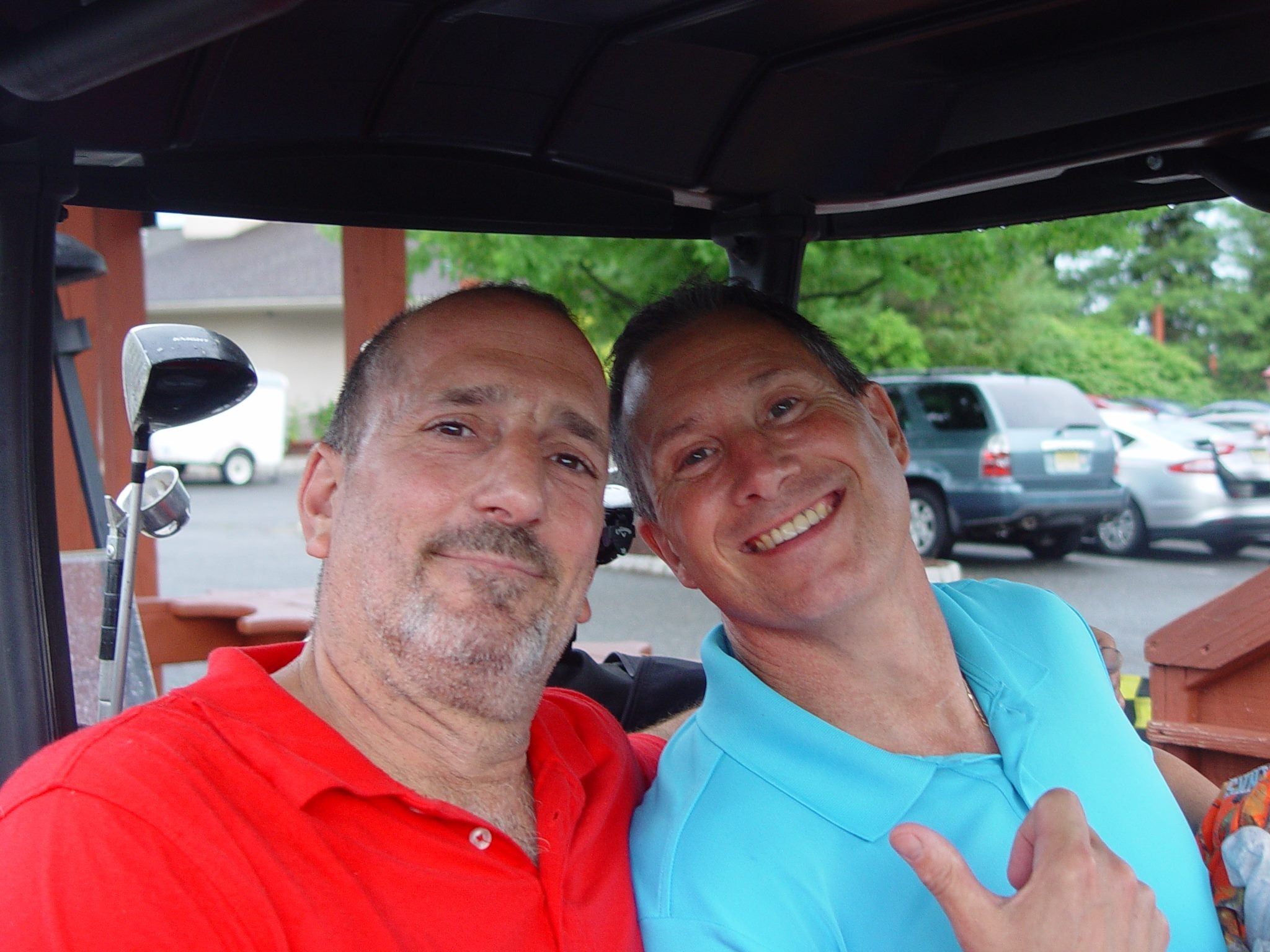 Men smiling in golf cart at Black Bear Bourbon &amp; BBQ