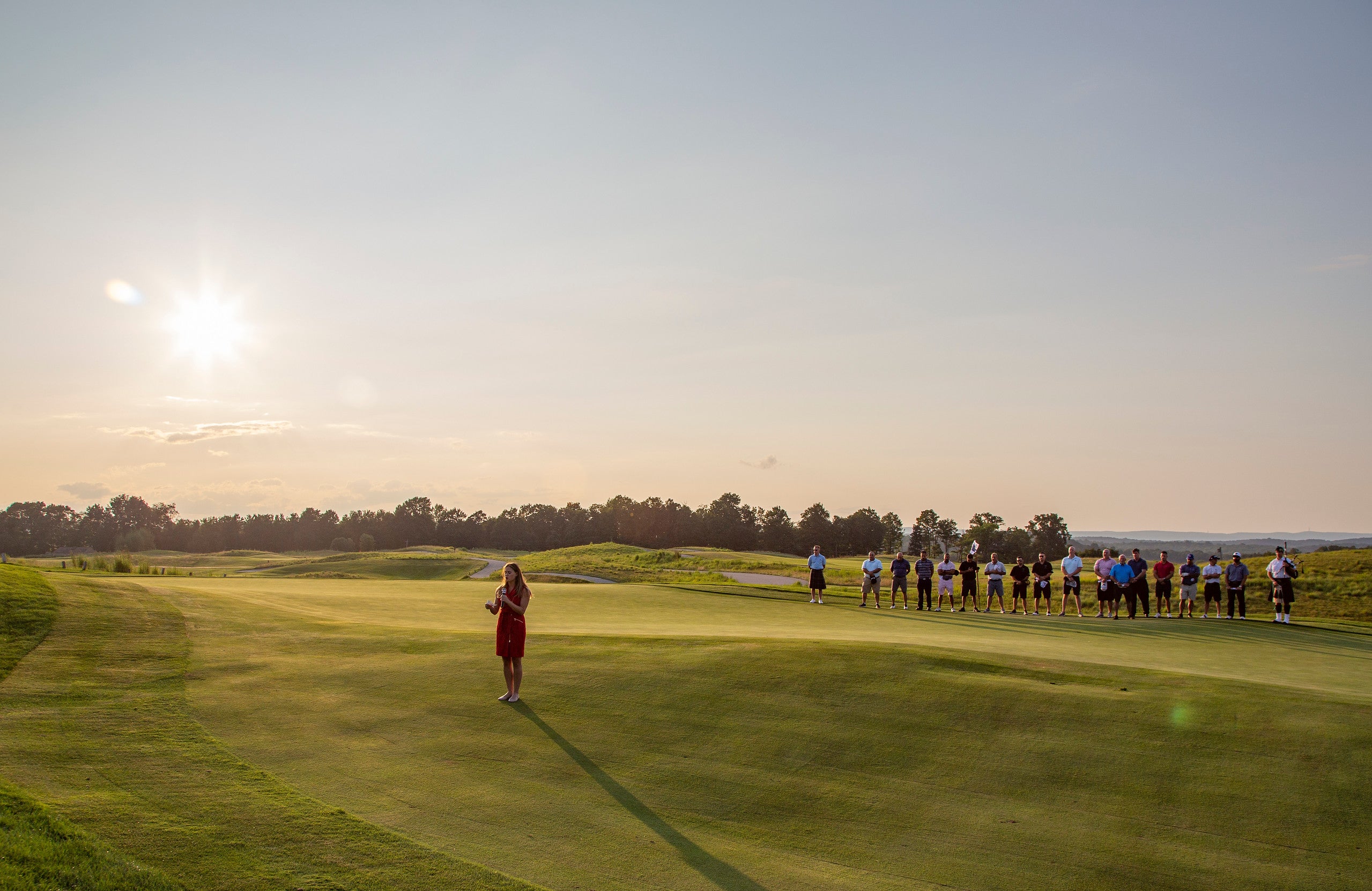 Girl wearing a red dress singing the National Anthem at the NJ Law Enforcement Open at Crystal Springs Resort