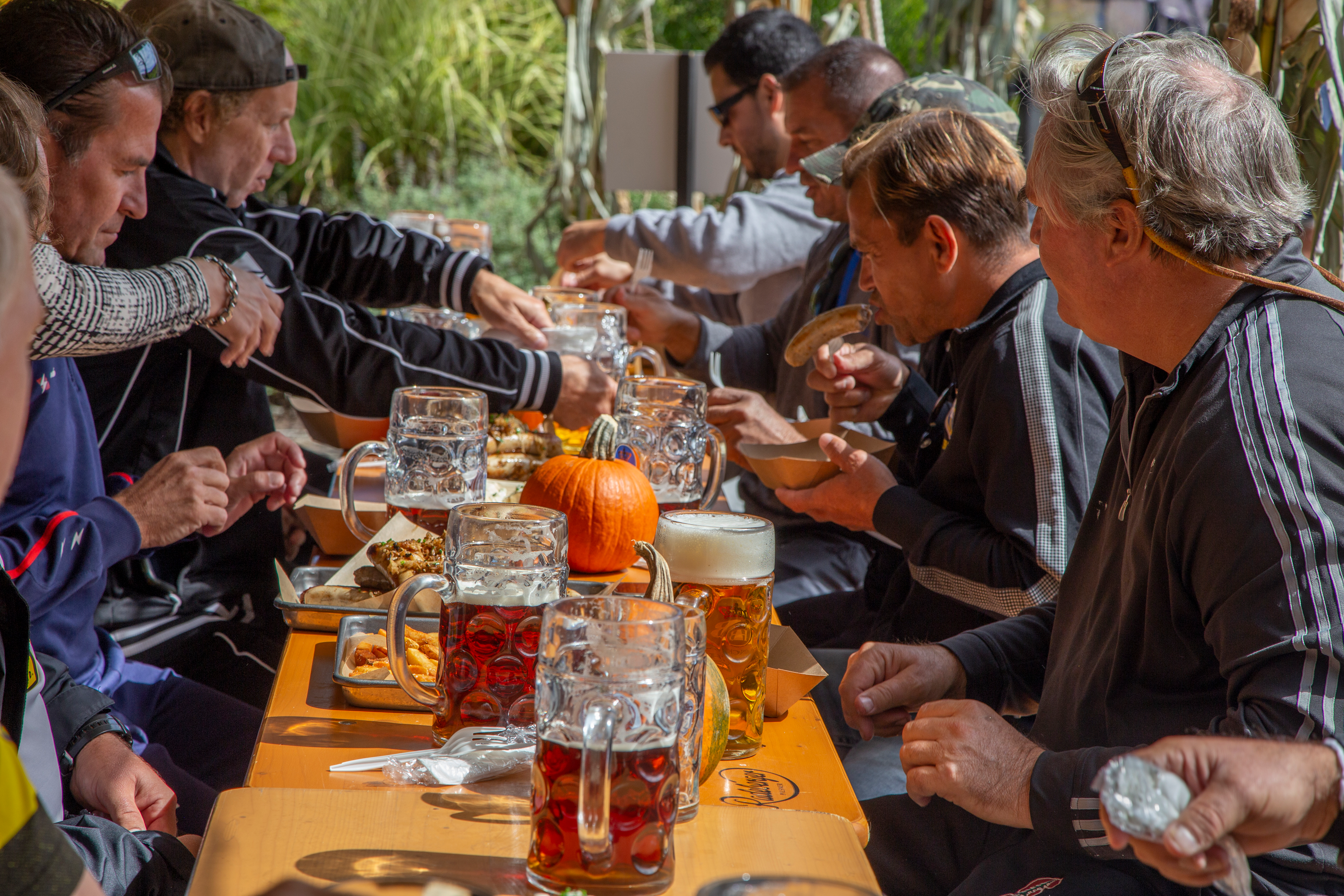 Group of people drinking steins of beer in Biergarten.