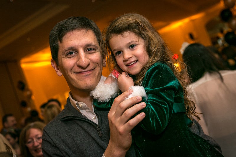 Father holding his young daughter celebrating New Year's Eve.