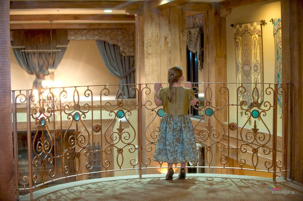 Little girl looking over Grand Cascades Lodge lobby balcony