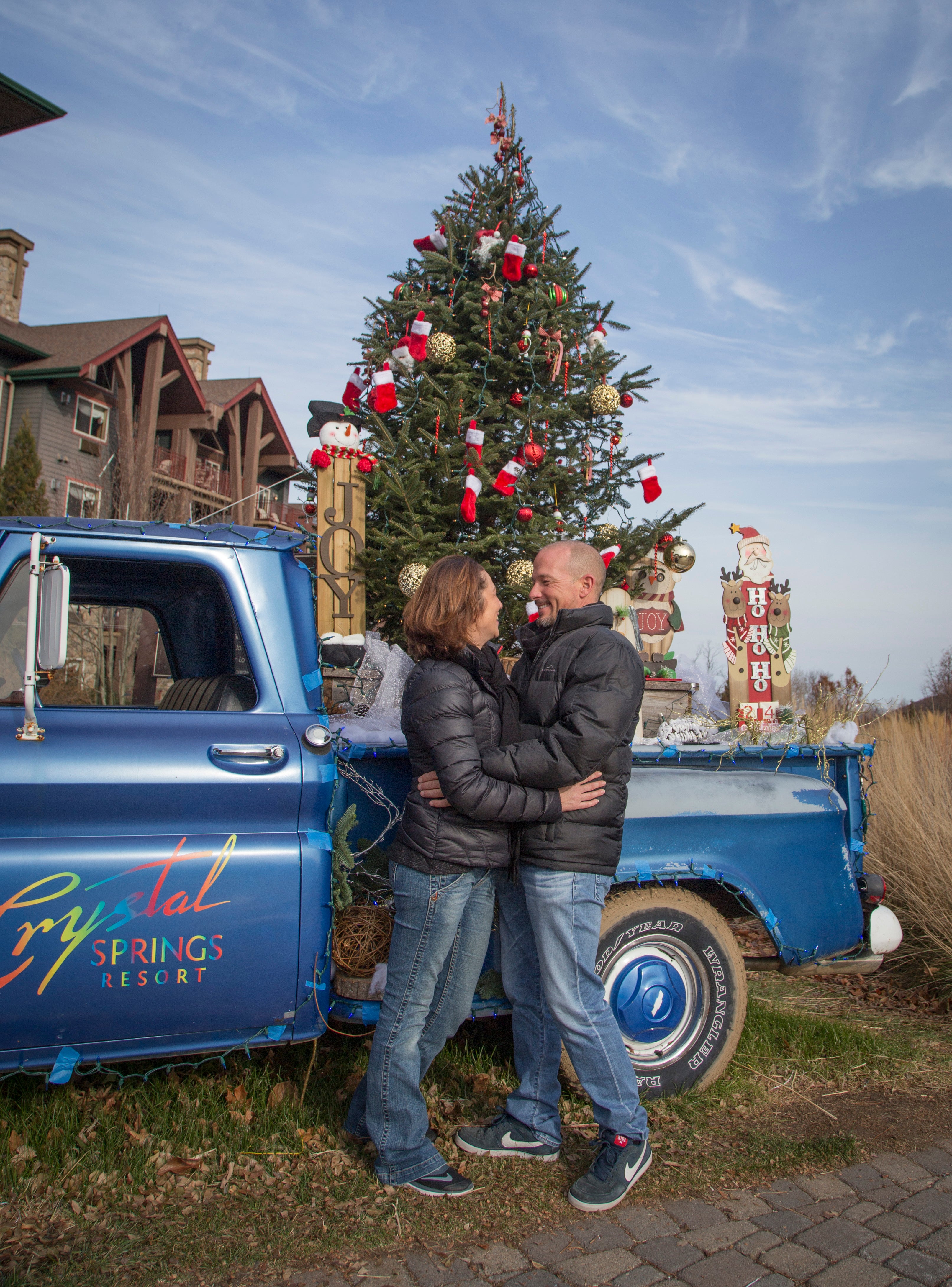 Couple in front of Christmas tree outside of Grand Cascades Lodge