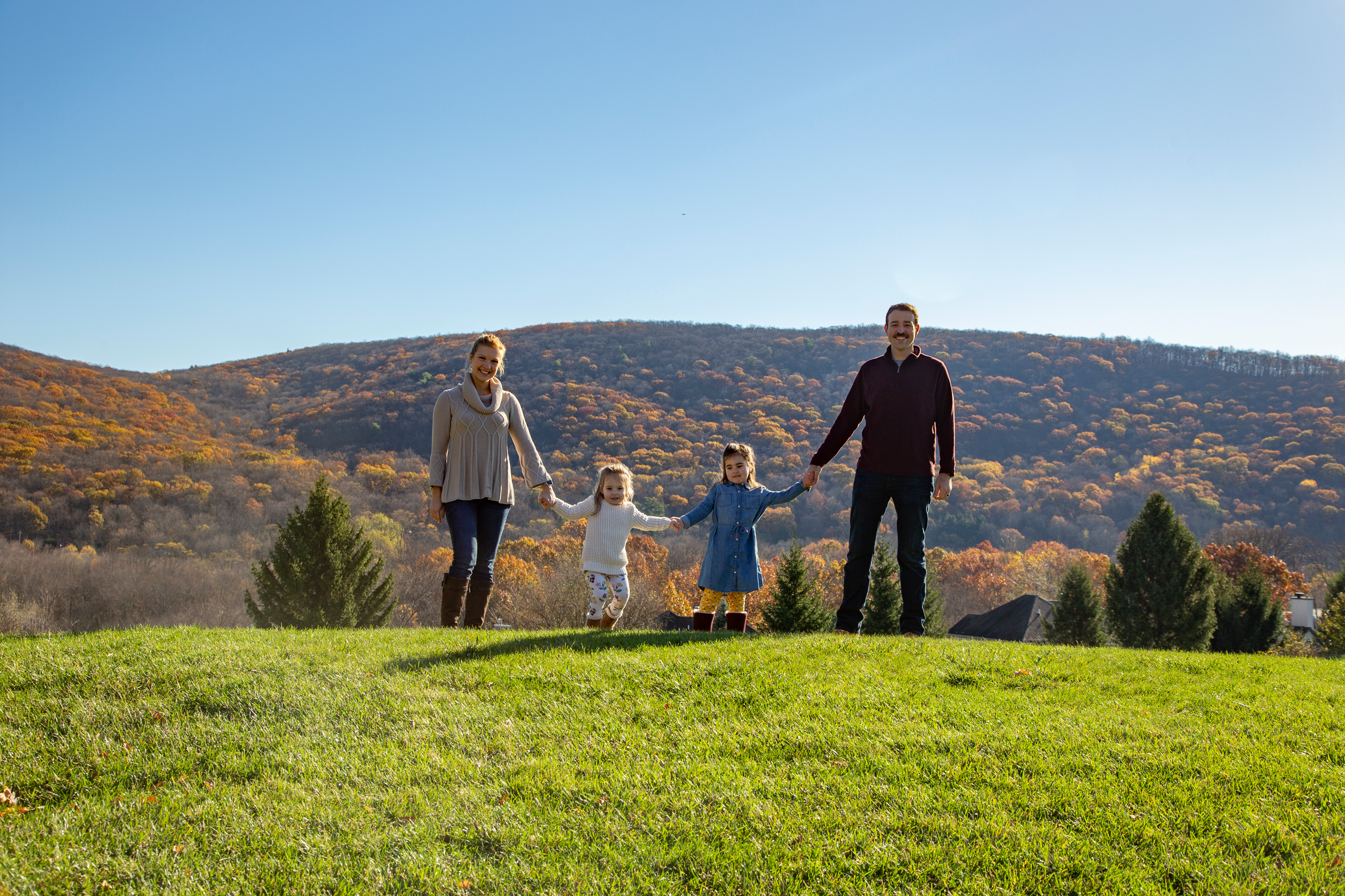 Family standing amongst the fall mountains
