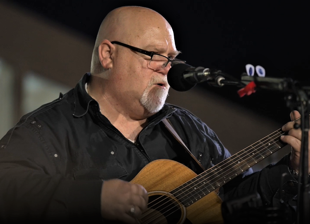 Man singing and playing guitar. 
