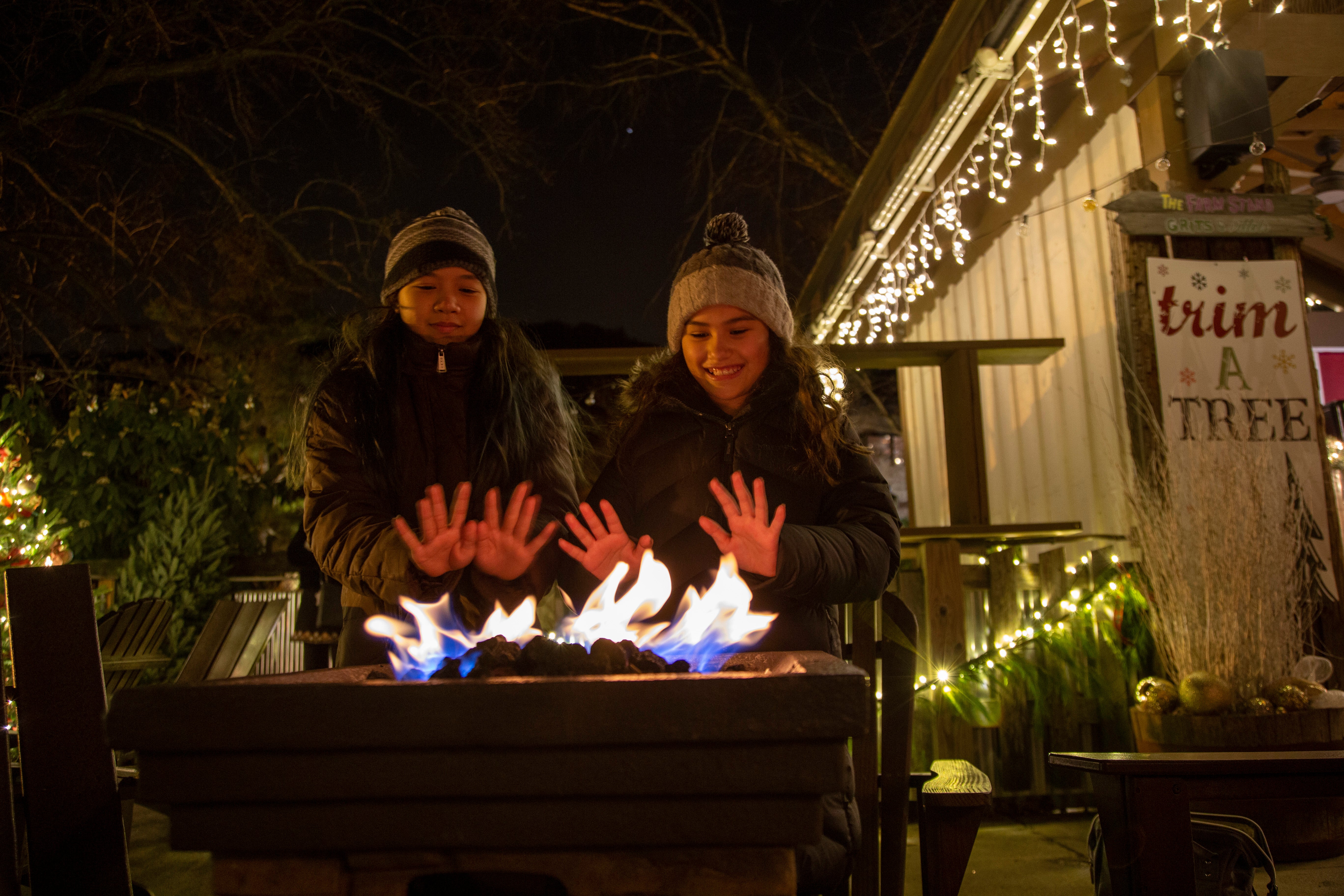 Two people warming hands up by fire.