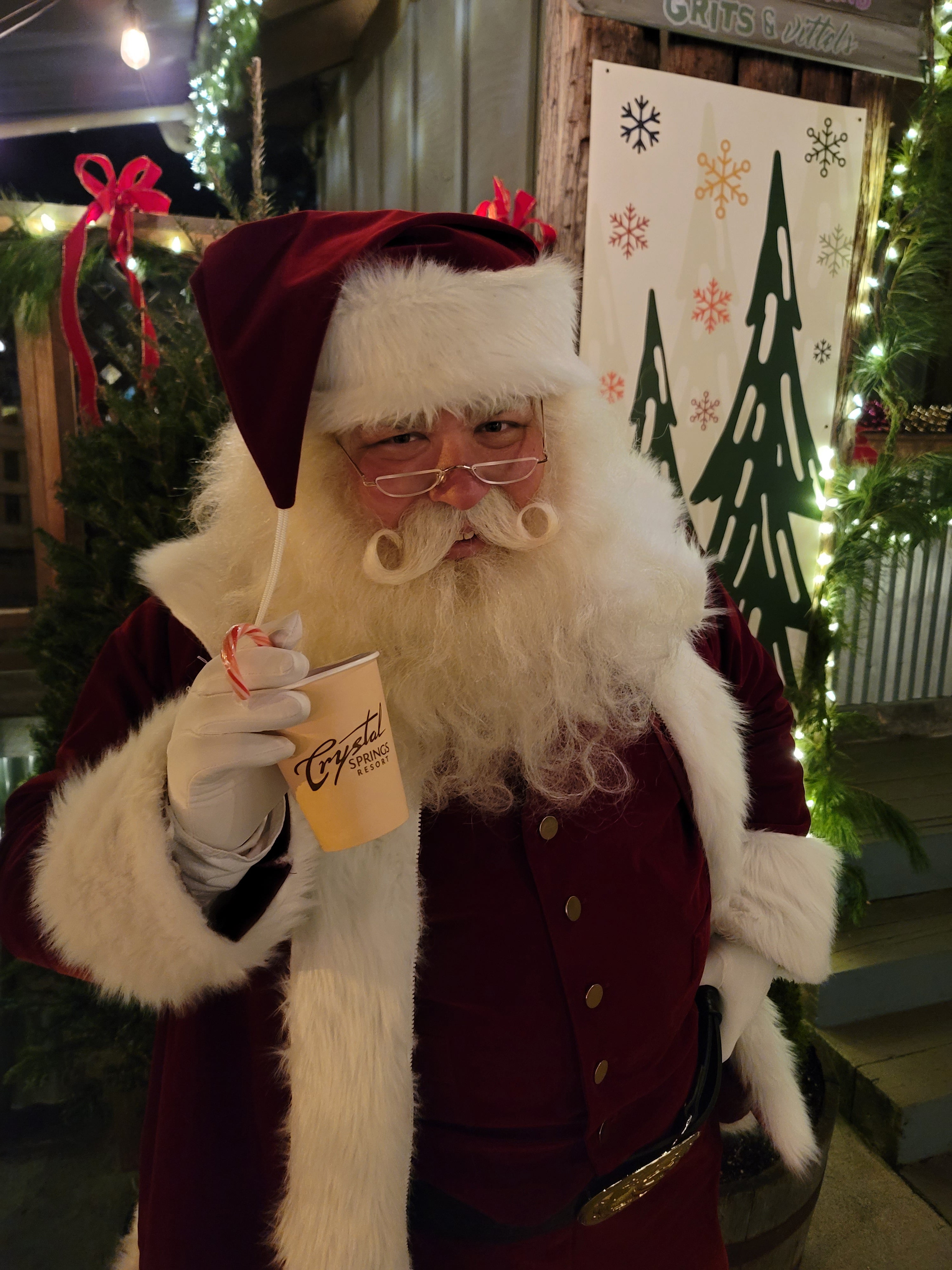 Santa holding cup of hot chocolate.