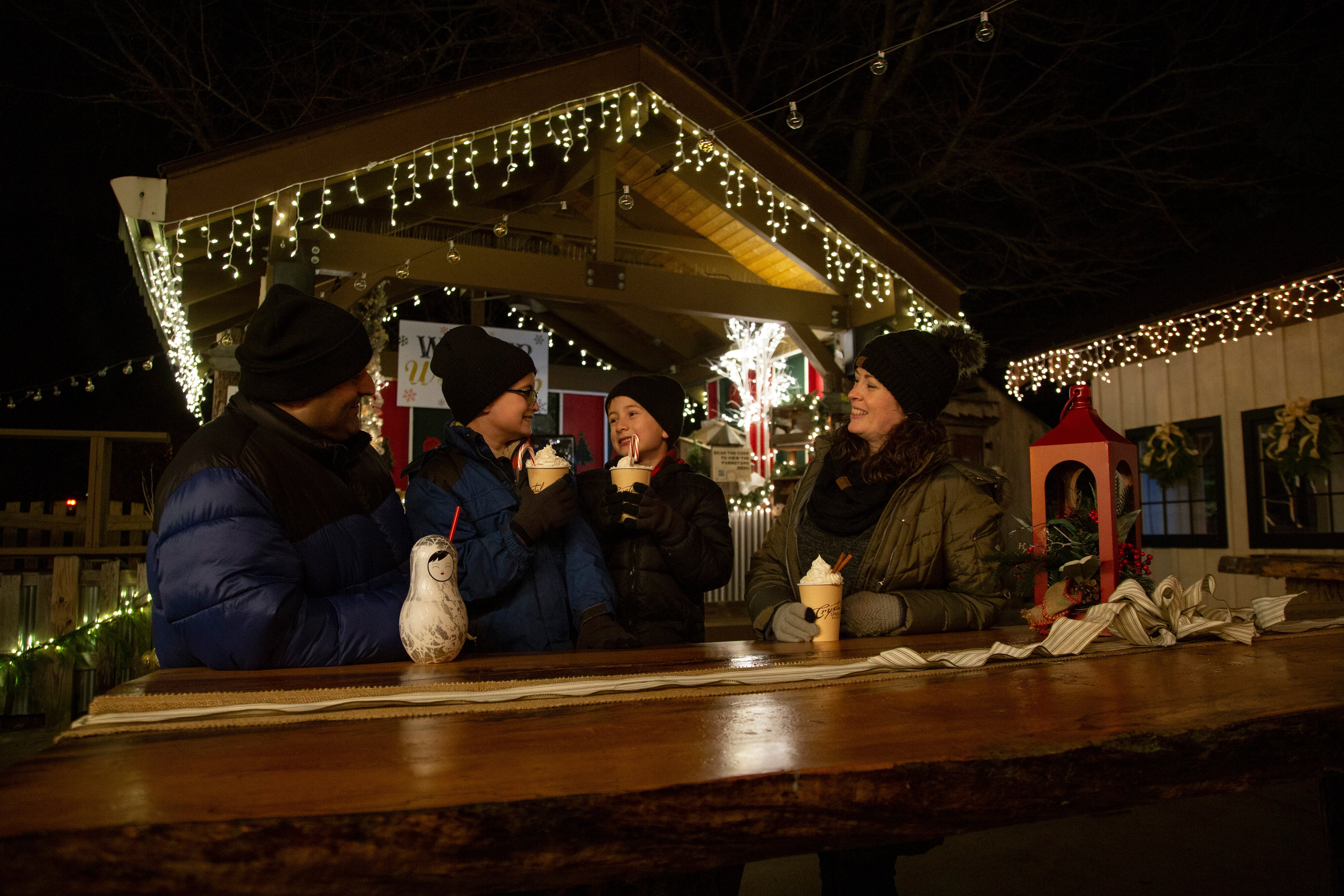 Family of 4 drinking festive drinks in Frosty's Cantina during vacation.