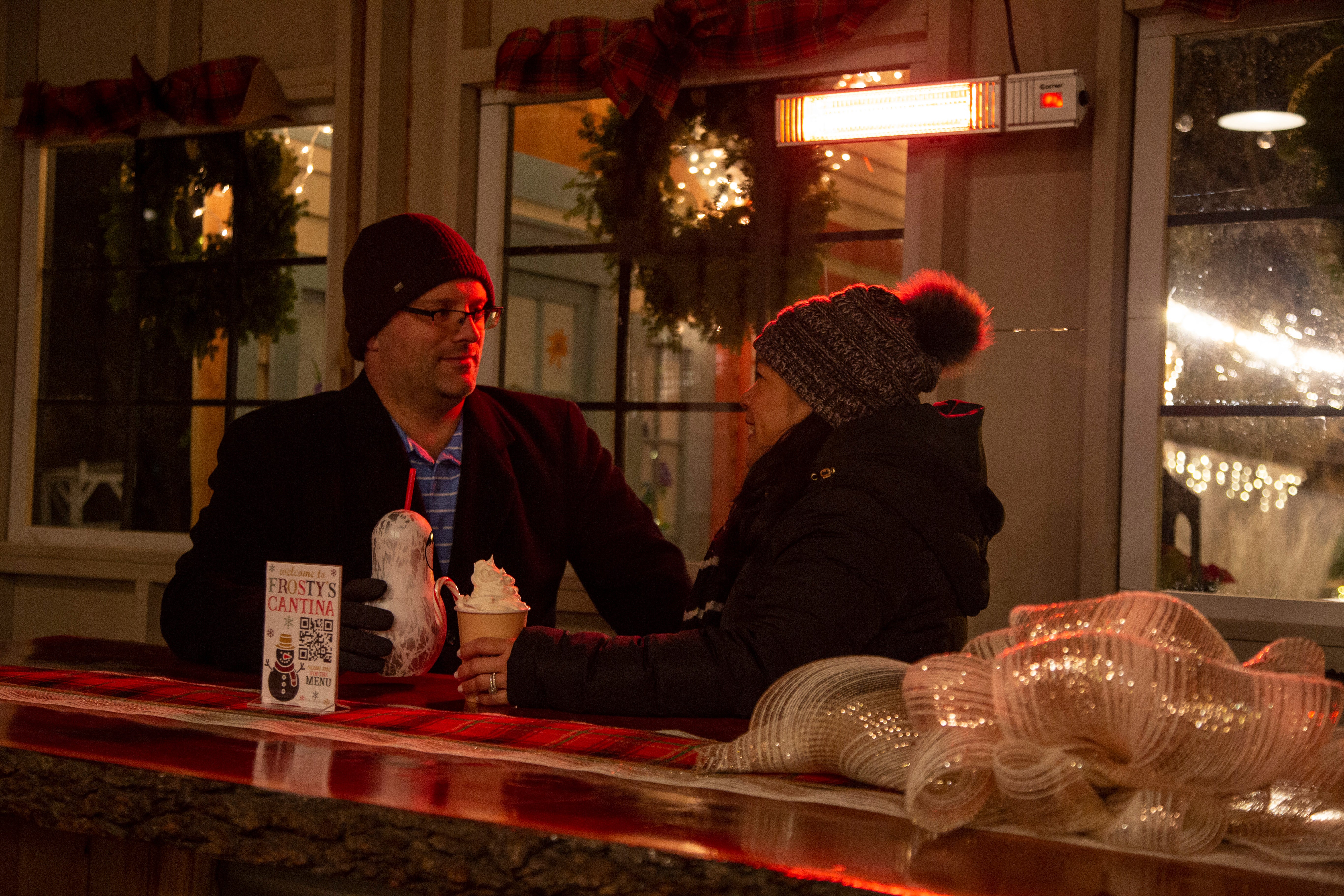 Couple sitting in Frosty's Cantina drinking festive beverages.