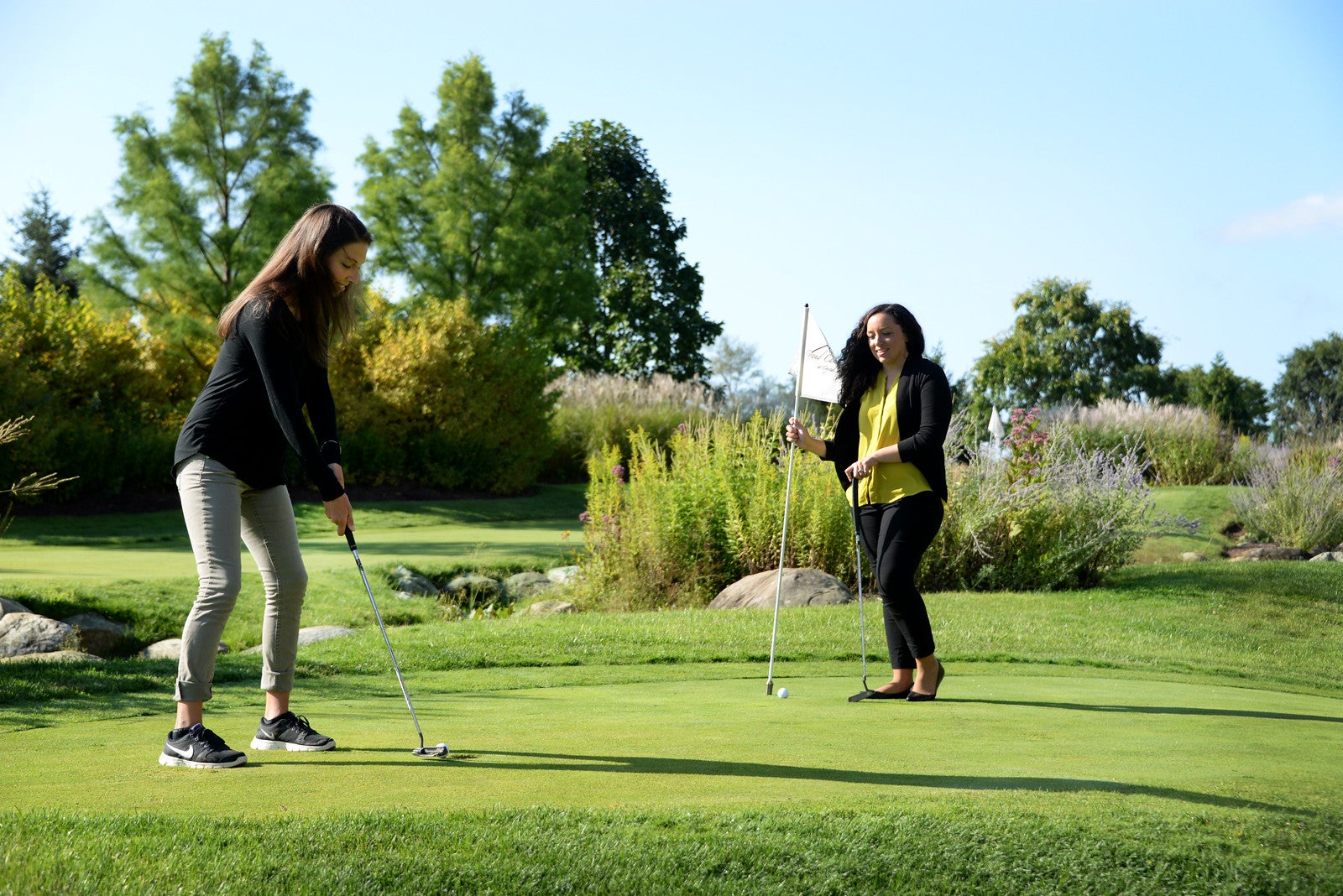 Girlfriends playing on the natural grass putting course at a resort close to NYC