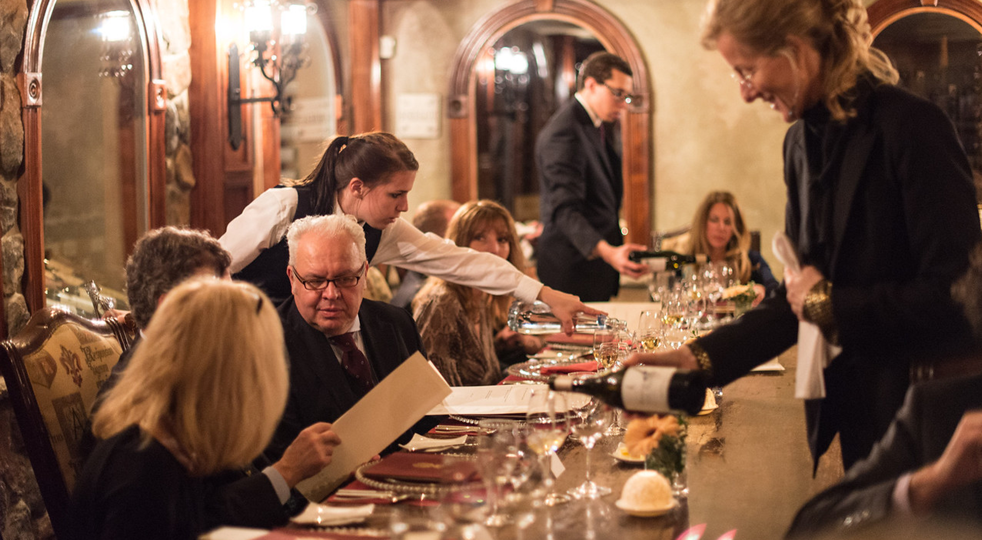 Group of people having dinner in the wine cellar.