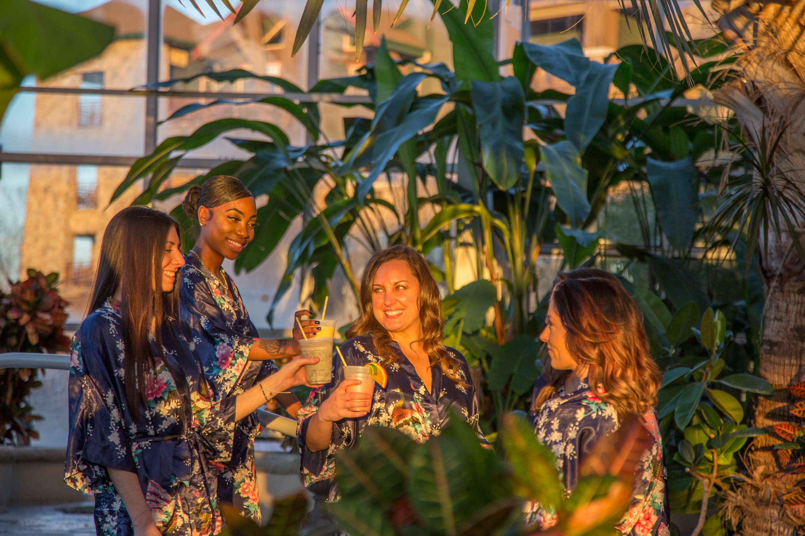 Four women in floral robes drinking in the Biosphere during girlfriends getaway.