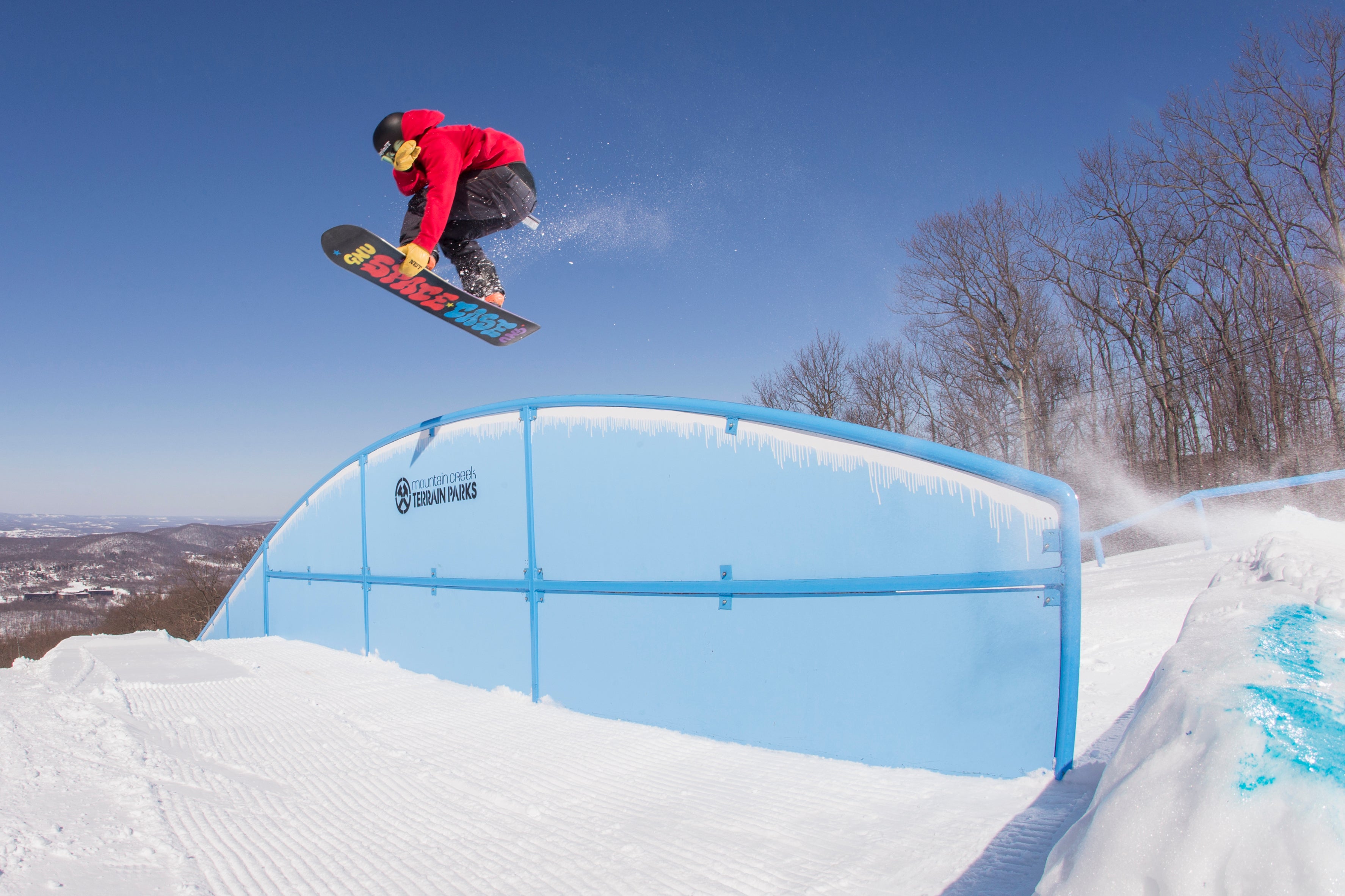 Person on snowboard jumping over lift.