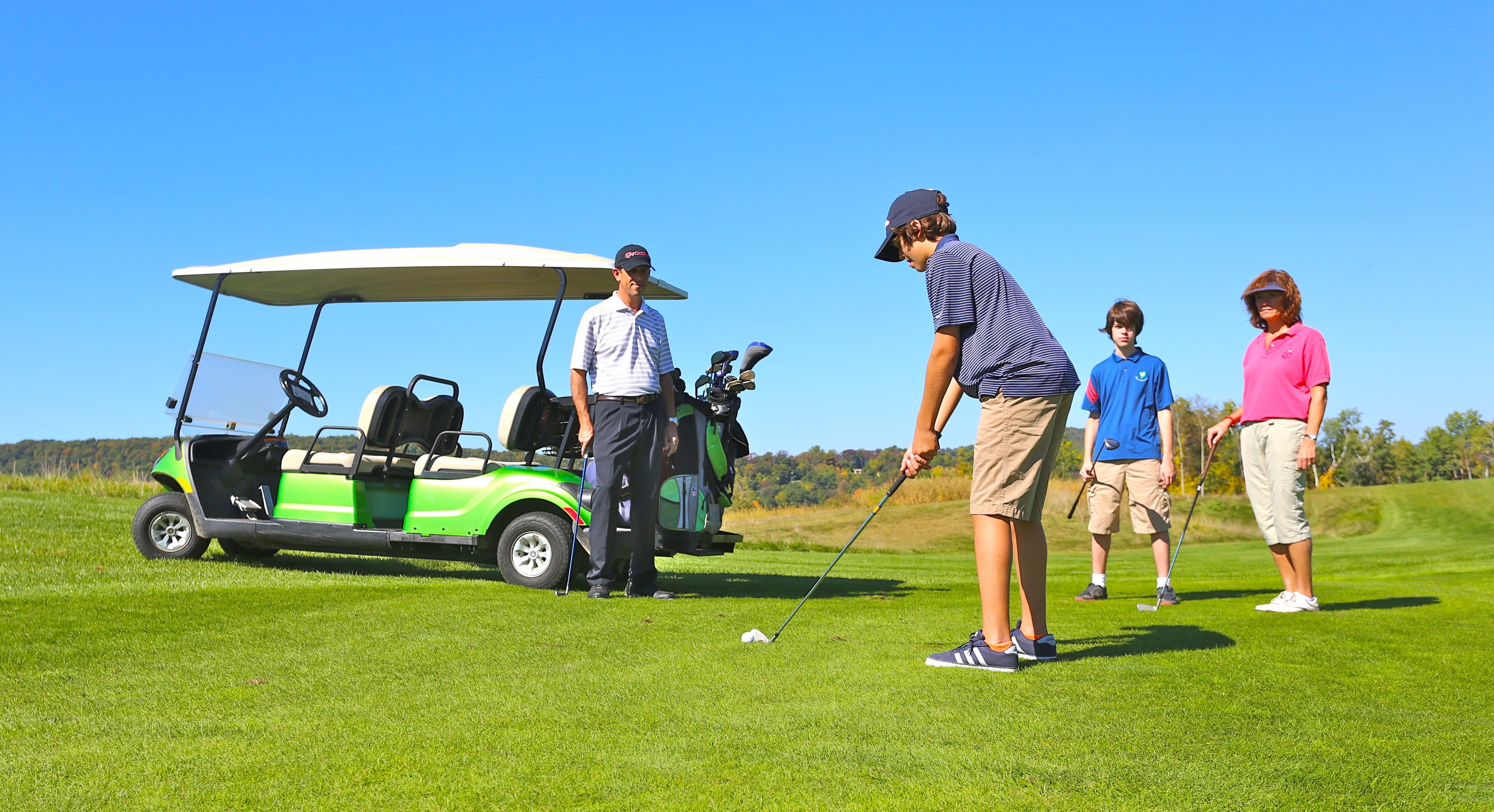 Family playing golf on a course at Crystal Springs Resort
