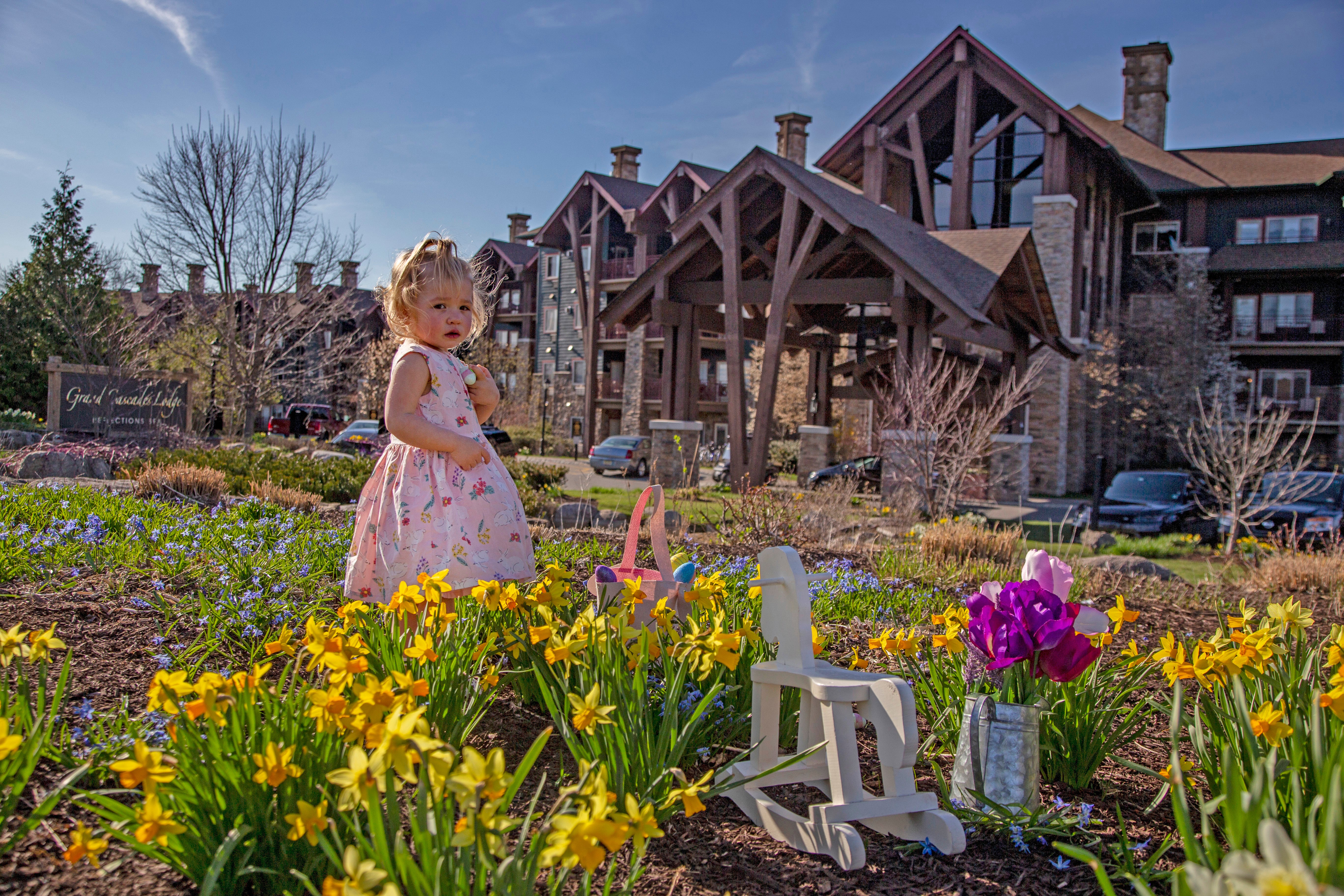 Young girl standing in tulips in front of Grand Cascades Lodge.