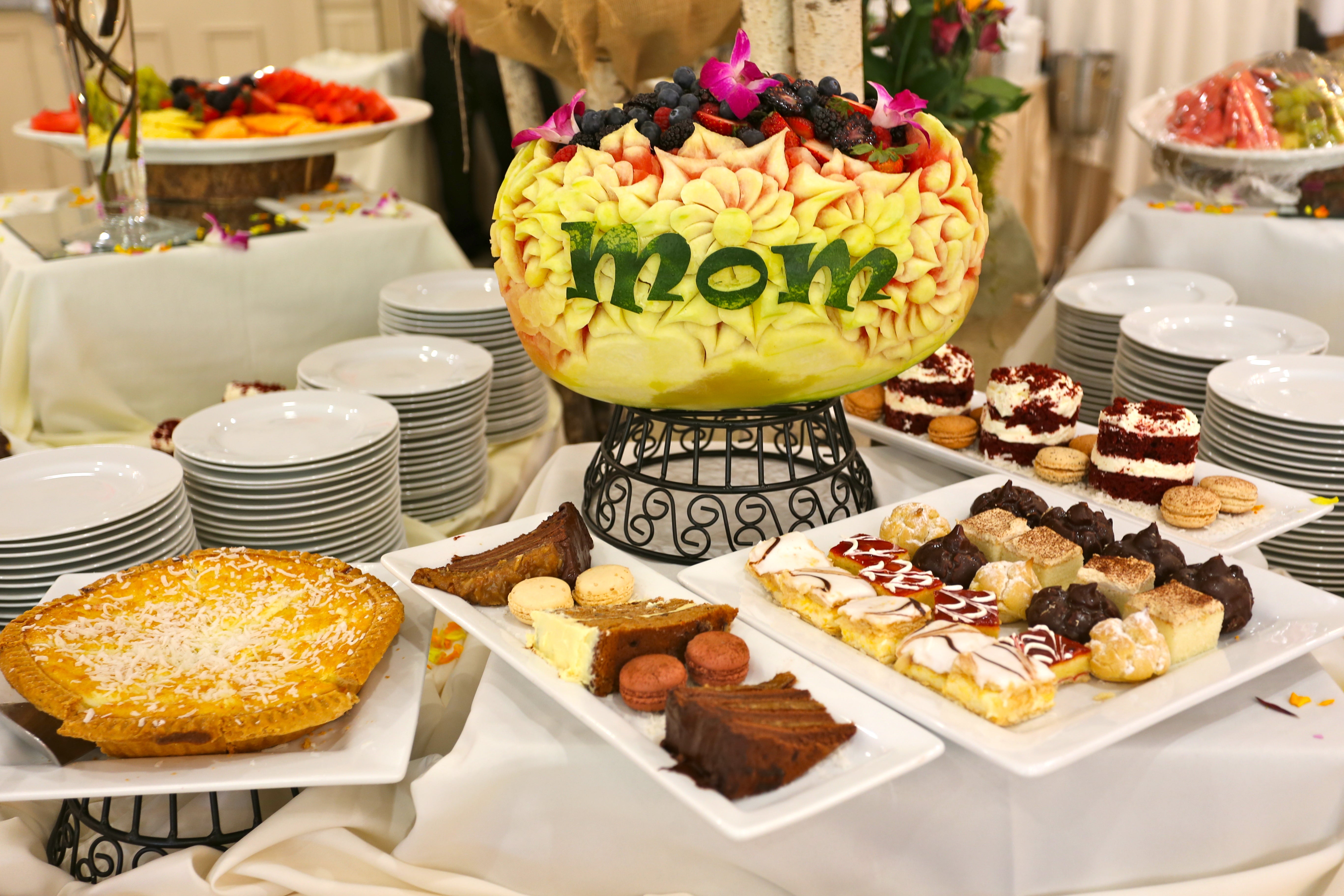 Melon carved to say &quot;mom&quot; at table of desserts