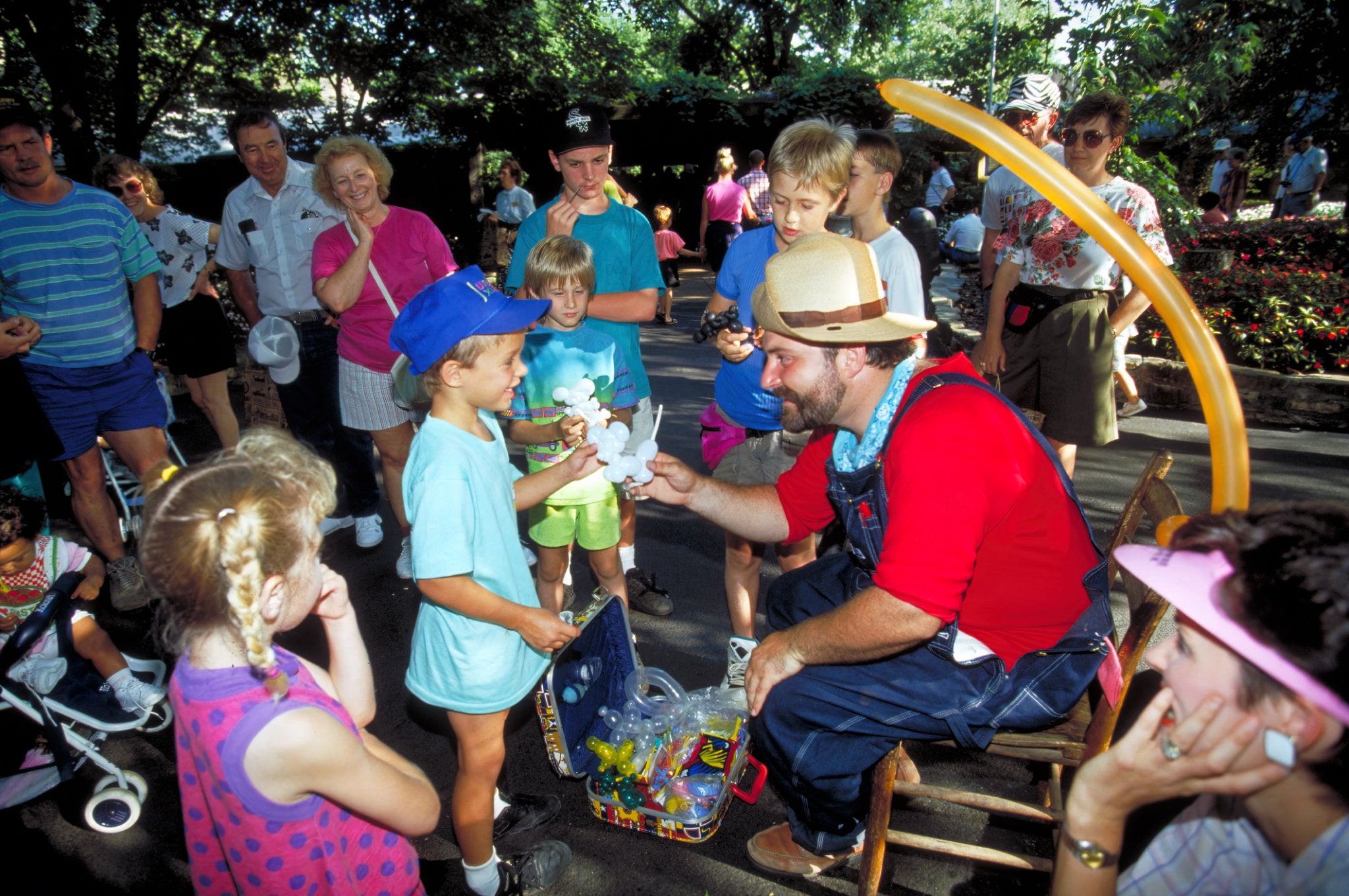 Guy making balloon animals for kid