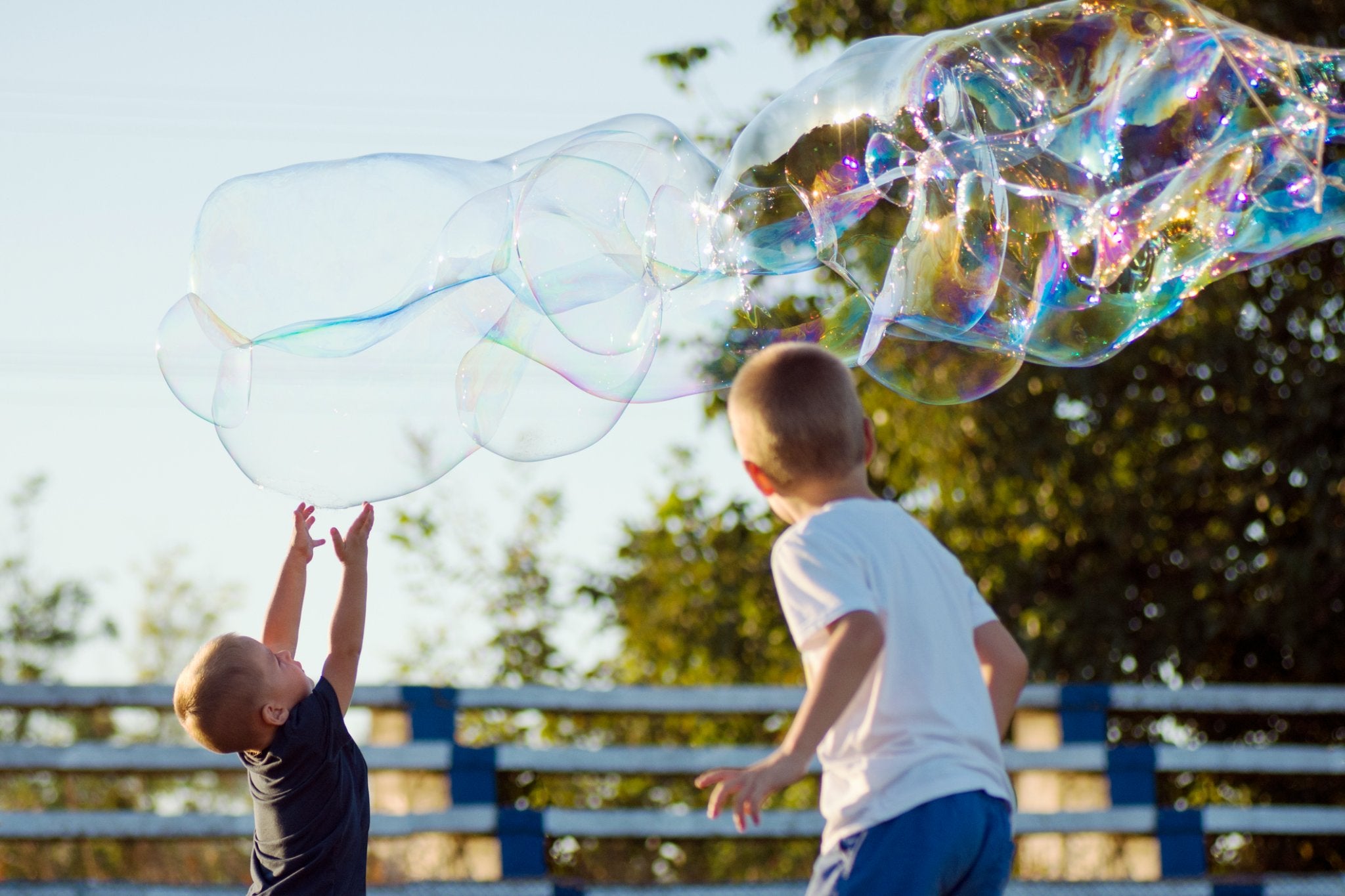 Two young boys playing with large bubbles